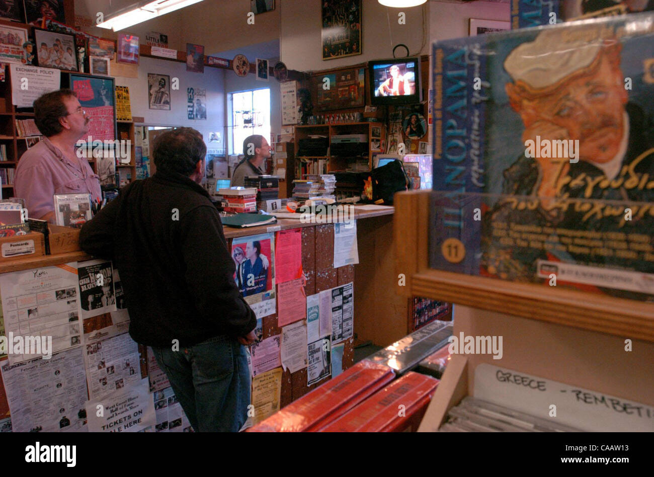 5:08 PM:  The staff and customers watch a DVD of the Beatles on the Ed Sullivan Show at Down Home Music at the front counter on Wednesday February 18, 2004 in  El Cerrito, Calif.   The famous store carries bluegrass, folk, and world music that other music stores do not keep in stock.  (Contra Costa  Stock Photo