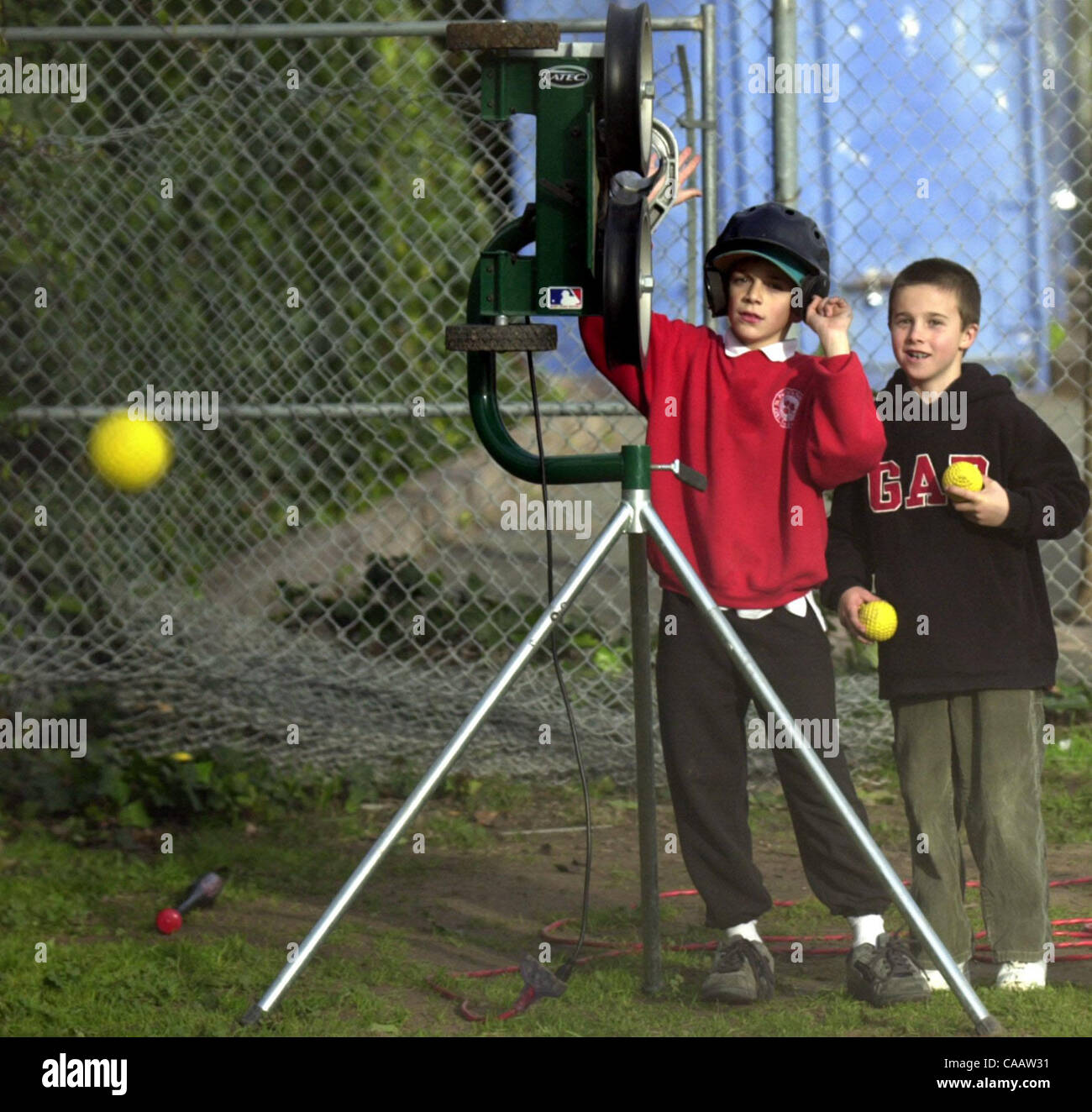 (l to r) Damon Palacio, 10, and Zachary Larson, 9, of the Blue Bombers launch a few 50mph fastballs out of the pitching machine at Left Gomez Field on Thursday February 5, 2004 in Rodeo, Calif.  The two have been practicing their hitting for two weeks and plan to practice up to the opening of the se Stock Photo