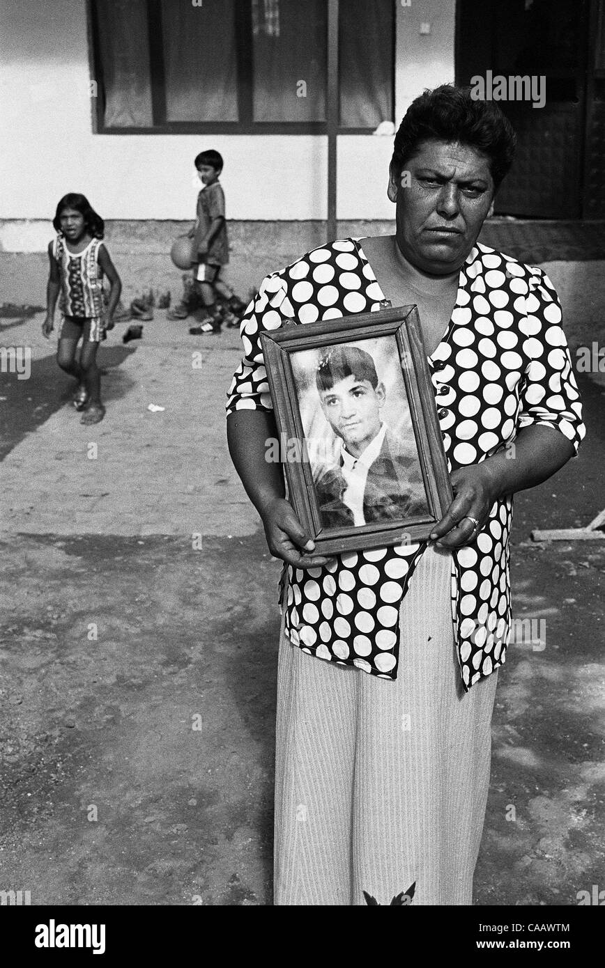An Ashkali woman in Kosovo holds a picture of her missing son, one of three local boys kidnapped by Albanians after the end of the war. Kosovar Albanians accused Gypsies (including the Ashkali)  of collaborating with the Serb army when it invaded the province in 1999, killing thousands of civlians. Stock Photo