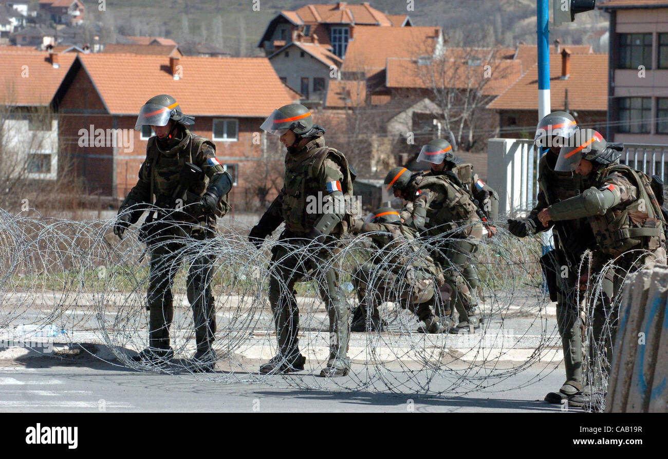 Mar 22, 2004; Kosovo, SERBIA; French soldiers, part of NATO-led peacekeepers in Kosovo (KFOR), spread barbwire during the guard watch in the North part of Kosovska Mitrovica, near the bridge that divides this troubled city into North (controlled by Serbs) and South (controlled by Albanians). Riots b Stock Photo