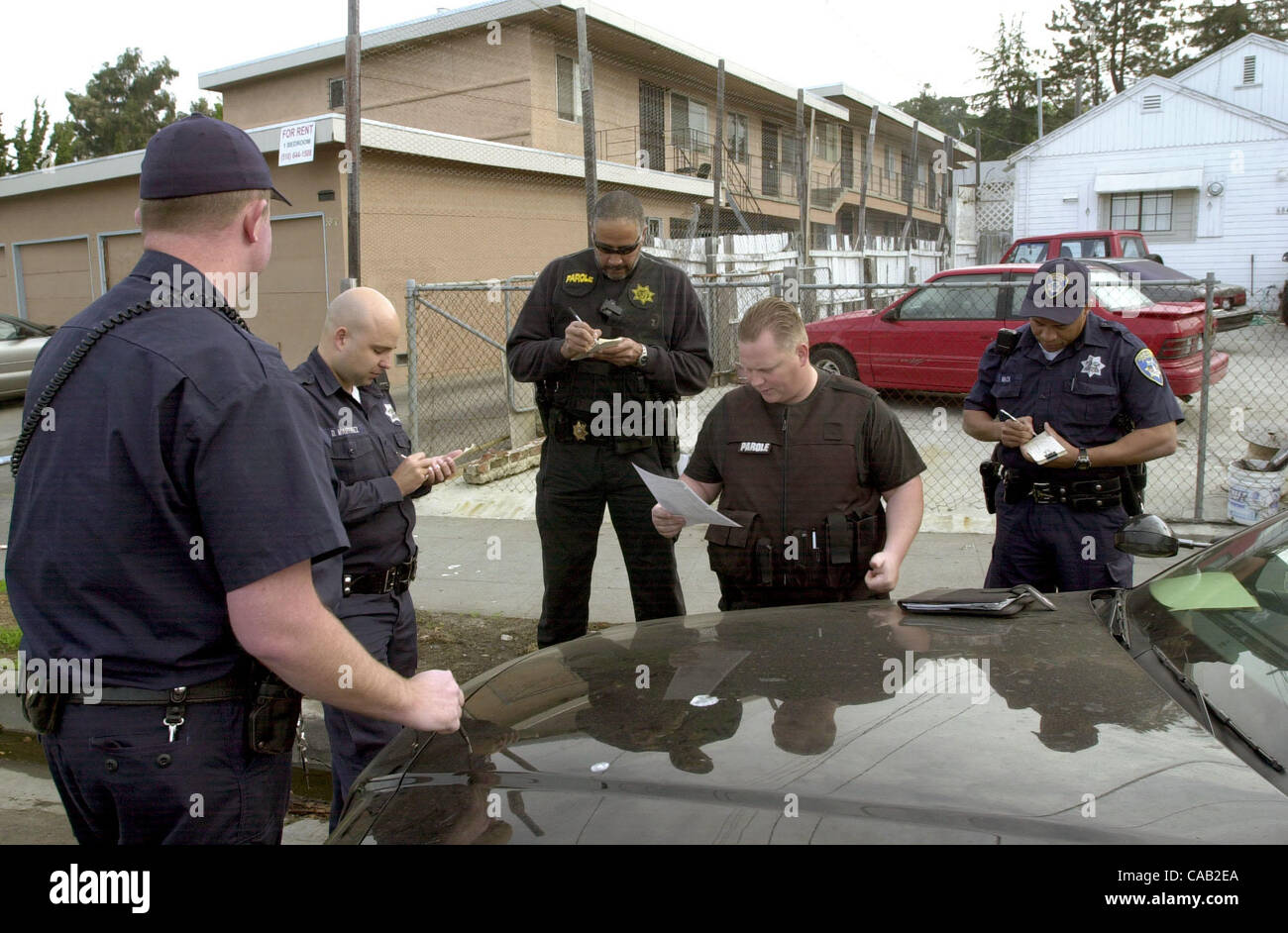 Oakland Parole agent officer Bent (2nd from right) goes over a face sheet with other member of the PACT team as they take notes in Oakland Wednesday March 28, 2004. (Contra Costa Times/Bob Larson)2004 Stock Photo