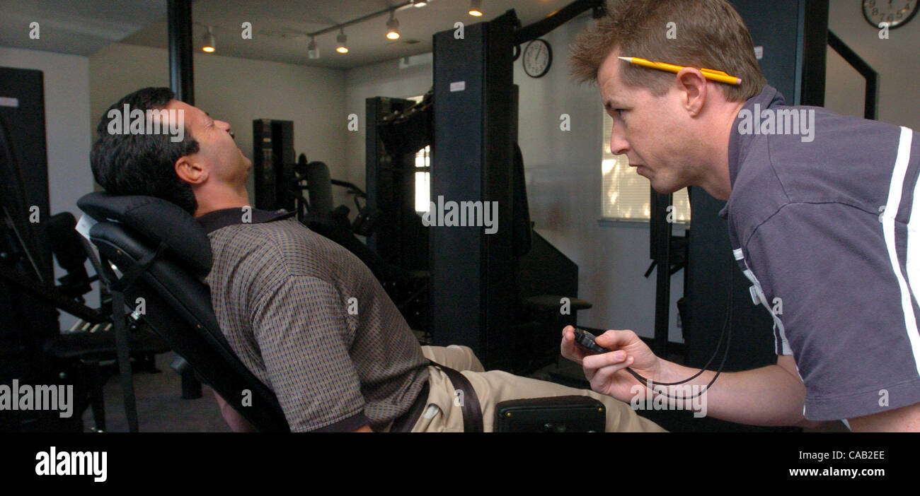 Fitness coach Andrew Stewart, right, times client Robin Leamy, of Lafayette, March 10, 2004 on one of the machines at the new 21 Minute Fitness and Weight Loss center in Walnut Creek, Calif.   (Contra Costa Times/Bob Pepping) Stock Photo