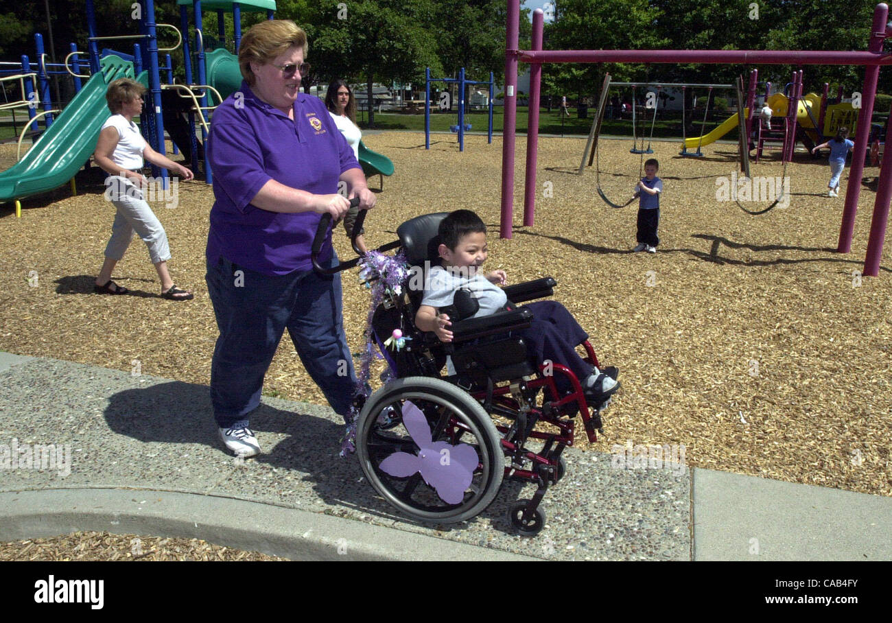 Liz Lamach wheels her disabled son Matteo, 4, into Hillcrest Park in Concord, Calif., on April 7, 2004.   Lamach is spearheading an effort to create an 'all-abilities' park where disabled and fully-abled children can play together on the same equipment.  At left is Matteo's other mom Rene Henderson. Stock Photo