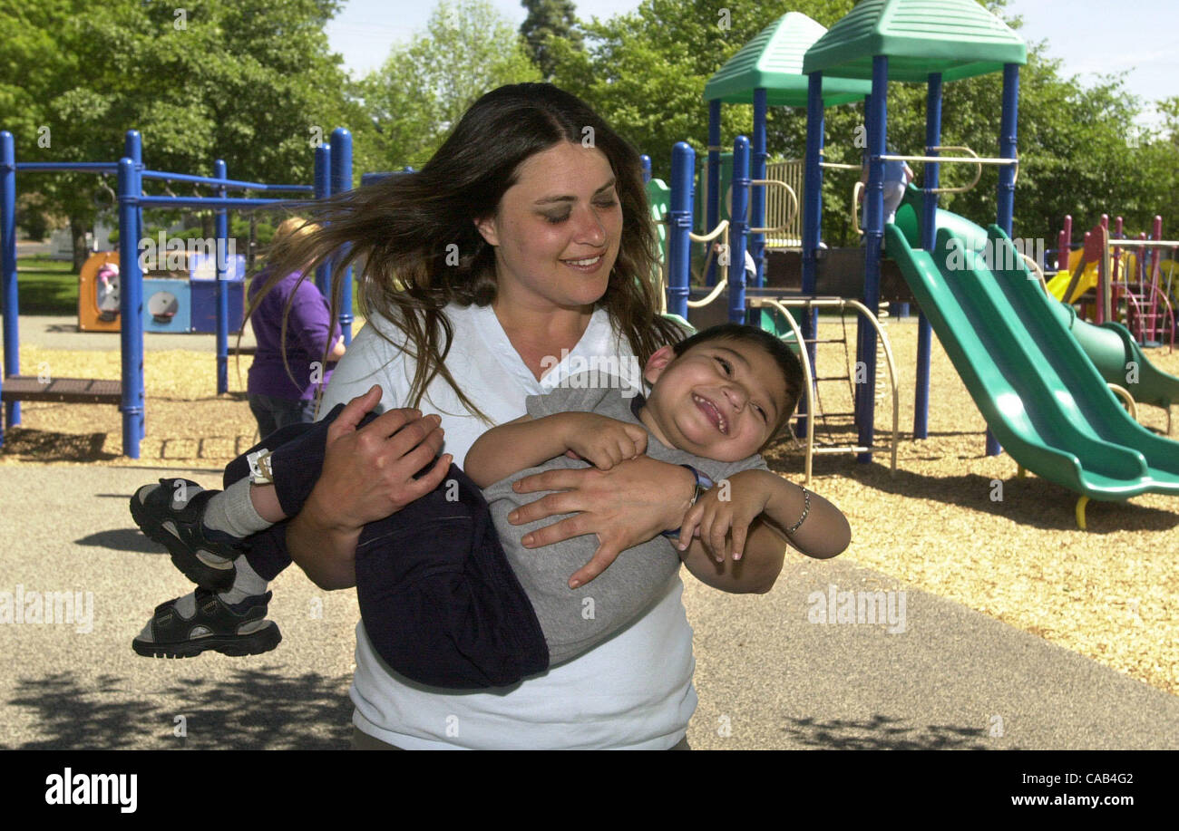 Monique Henderson, who describes herself as Matteo's 'favorite' aunt, plays with him April 7, 2004, during an outing to Hillcrest Park in Concord, Calif.   Matteo's mom, Liz Lamach is spearheading an effort to create an 'all-abilities' park where disabled and fully-abled children can play together o Stock Photo