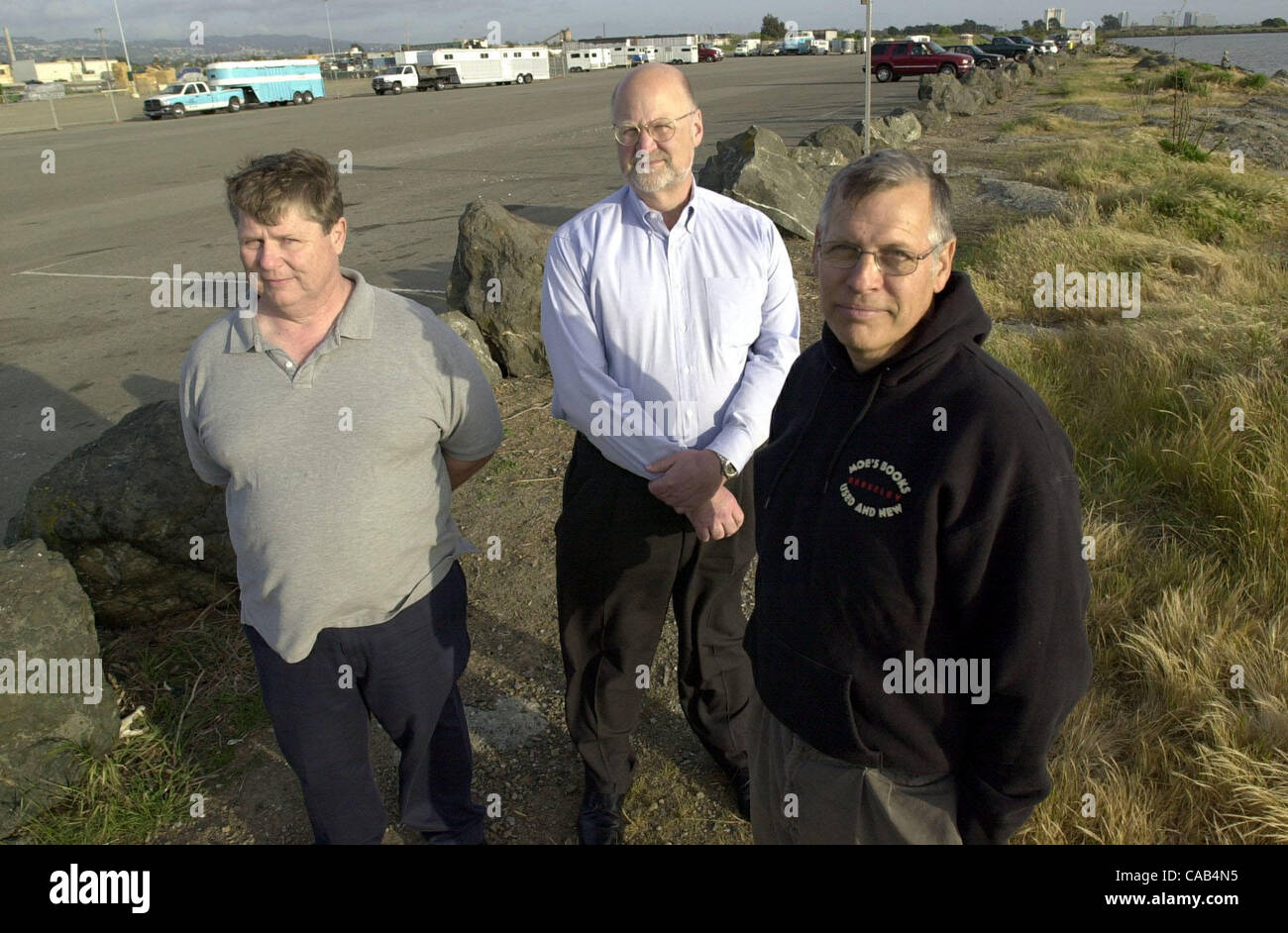 Roger Carlsen, left, Rich McClure, center, and Doug Fielding, right, stand in the parking lot next to the entrance of Golden Gate Fields where Gilman Street dead ends at the S.F. Bay in Albany, Calif., on Tuesday, April 13 , 2004. These guys have been working to get ball fields built on this parking Stock Photo