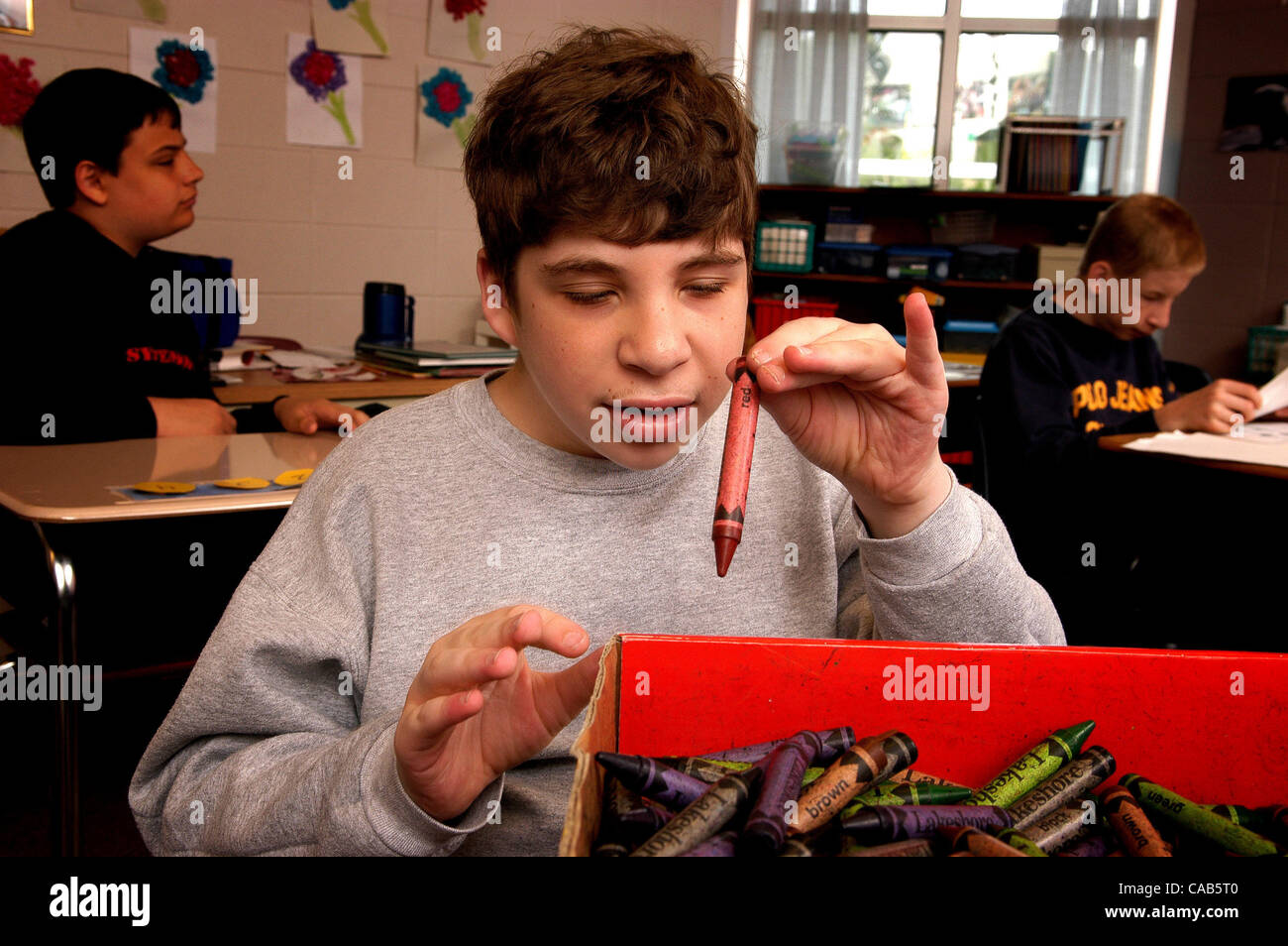 May 01, 2004; Woodstock, USA; An autistic teen boy sorts crayons by color Stock Photo
