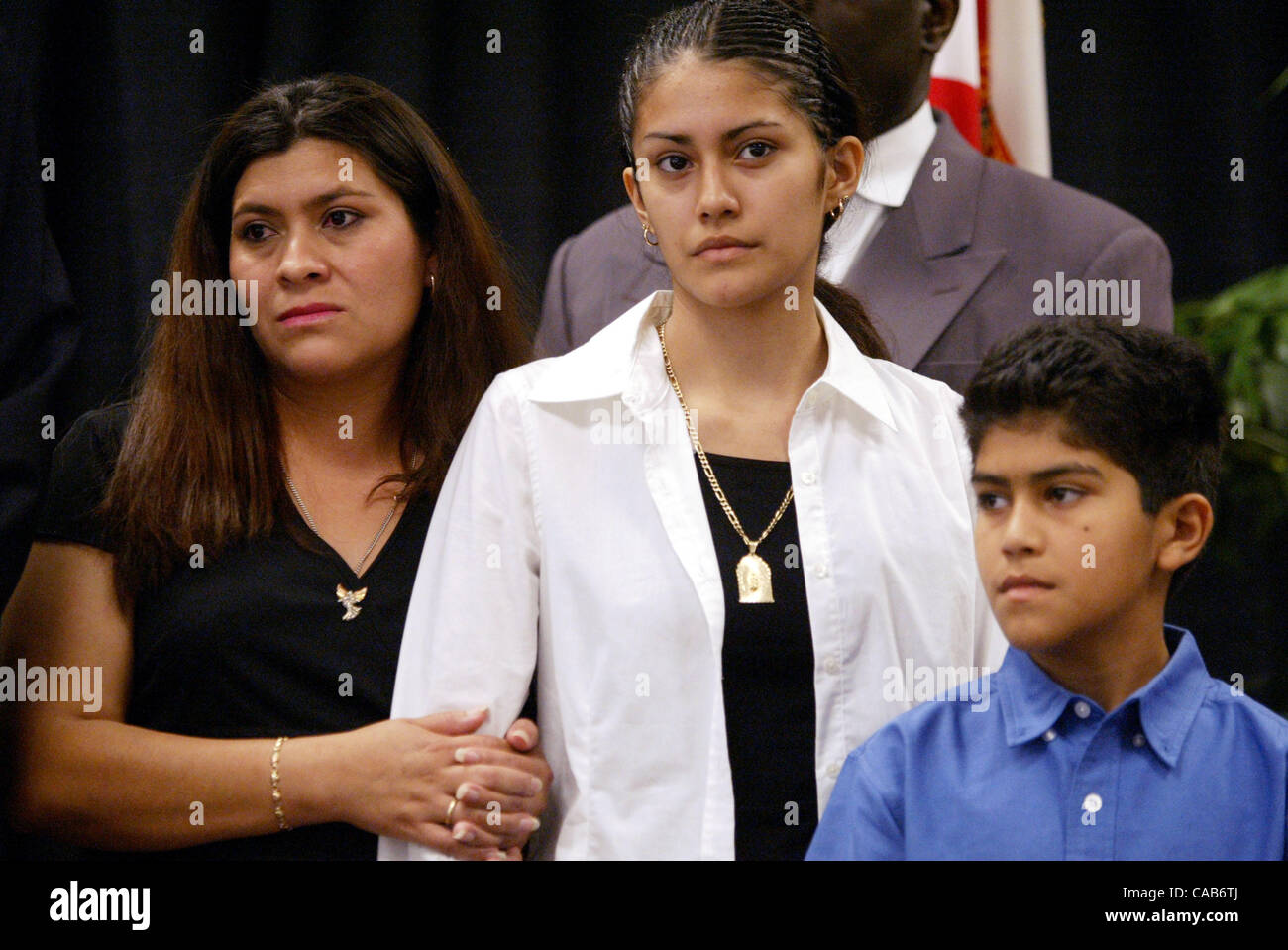 051404 met migrant3--Immokalee, Fla.--Evangelina Bahena, left, with her daughter Gabriela Bahena, 13, and son Xavier Bahena, 9, all of DeLeon Springs, Fla. at a ceremony recognizing the Alfredo Bahena Act, a new law named after her husband who was killed in an accident April 18, 2003, signed by Gove Stock Photo