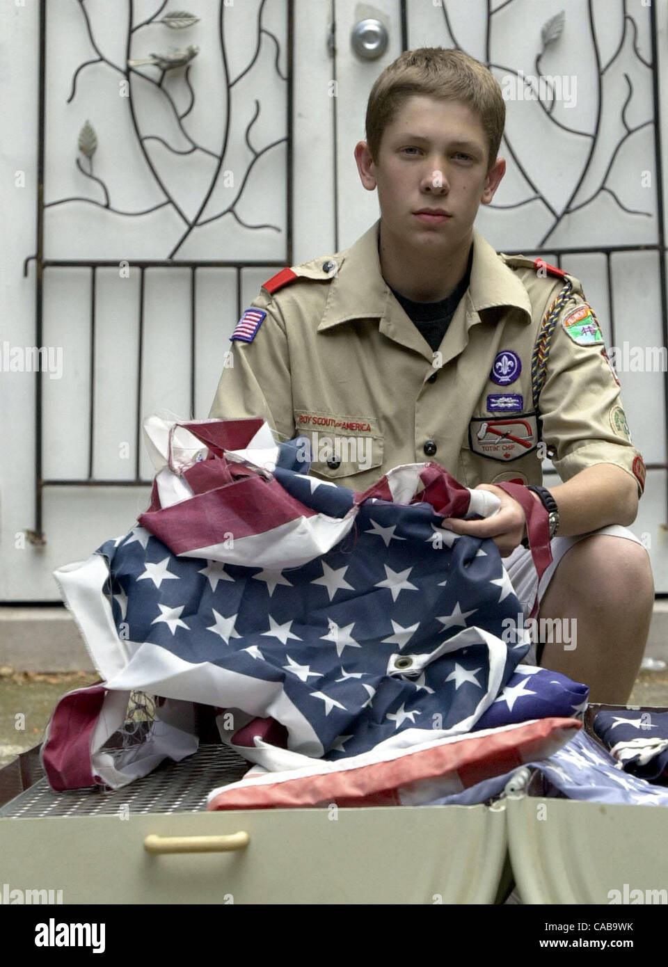 Boy Scout Stephen Renner poses with American flags at home in Piedmont, Calif., on Tuesday, May 25, 2004. Renner will properly retire the flags by burning them in a fire pit he constructed at Mountain View Cemetary on Memorial Day, Monday May 31st. This will complete his Eagle Scout community servic Stock Photo