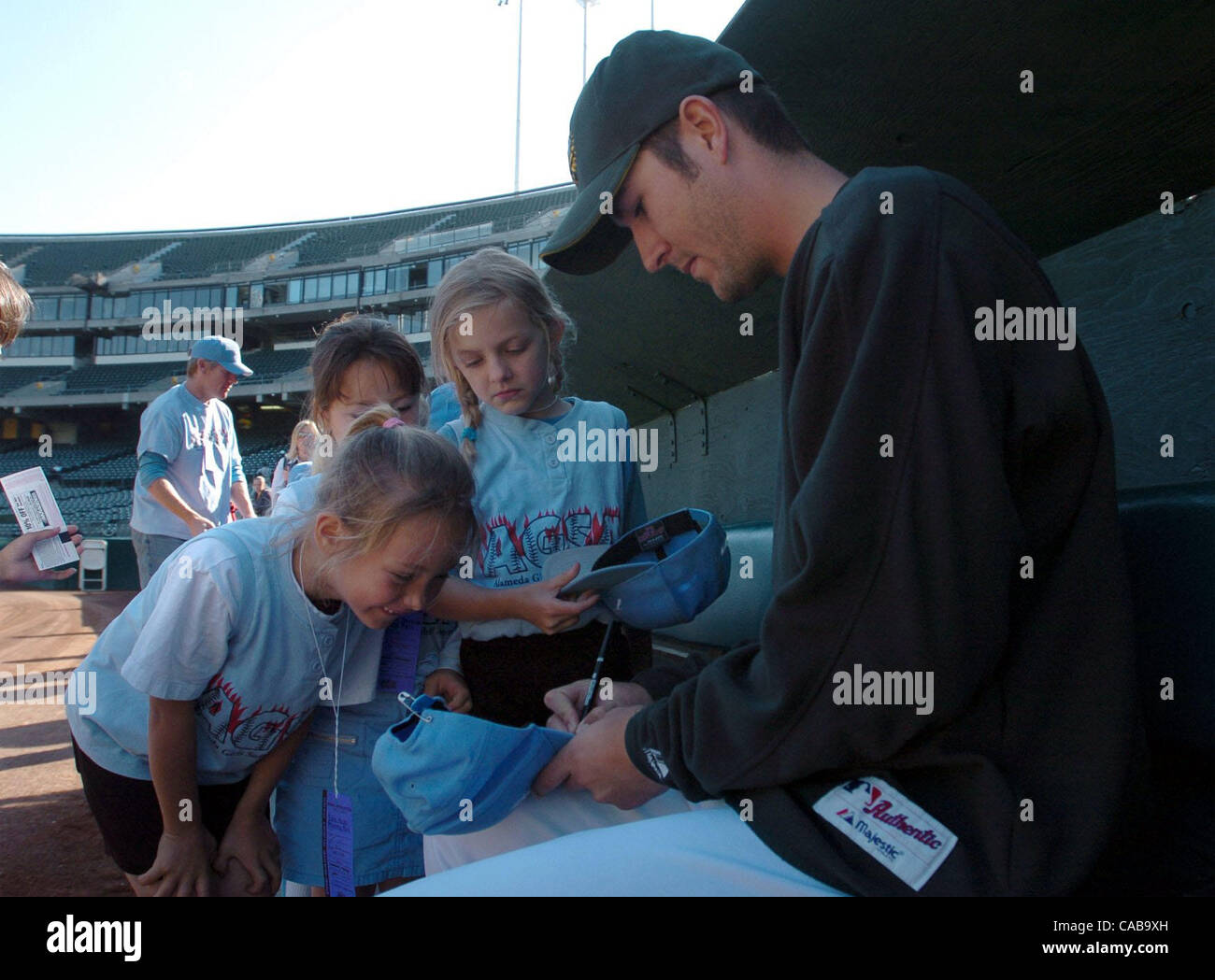 Pitcher Justin Duchscherer signs a few autographs for  the girls of Blue Angels softball team on Wednesday May19, 2004 in Oakland, Calif.   The team won a contest to learn a little about pitching from an Oakland A's pitcher.   (Contra Costa Times/ Gregory Urquiaga) Stock Photo