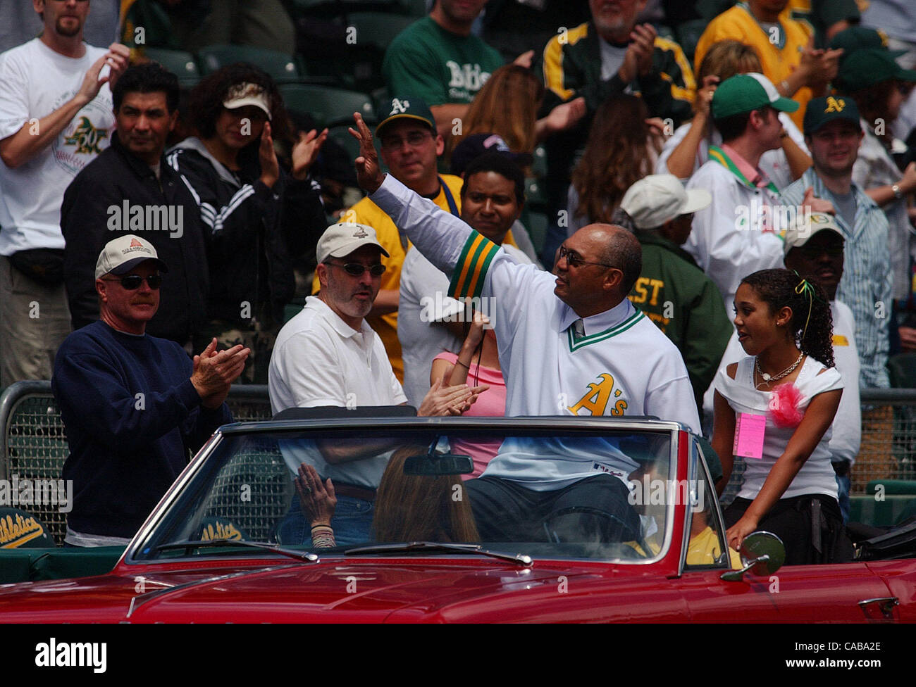 Reggie Jackson and his daughter Kimberly wave to the crowd as they enter Network Associates Coliseum for a pre-game ceremony retiring Jackson's number on Saturday, May 22, 2004 at the Oakland Coliseum in Oakland, Calif. (Jose Carlos Fajardo/Contra Costa Times) Stock Photo