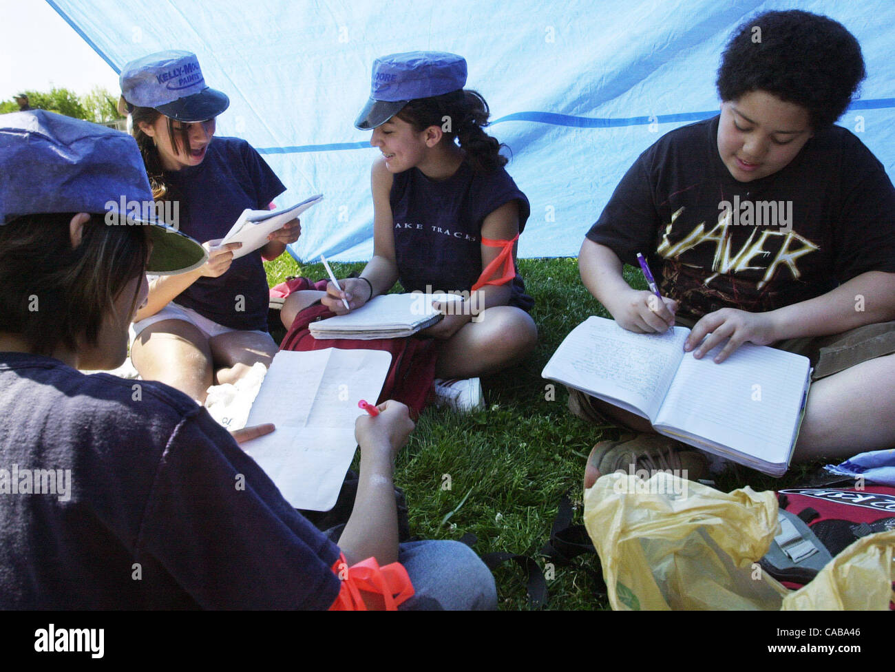 Eighth graders are writing in their journals while hanging out in their tents during the re-enactment of the Civil War at Walnut Creek Intermediate in Walnut Creek, Calif. on Friday, May 14, 2004.  Left-right are: Elena Nagamine (back), 14, Alex Souchkova, 14, Frances Hurley, 14, and Cameron Johnson Stock Photo