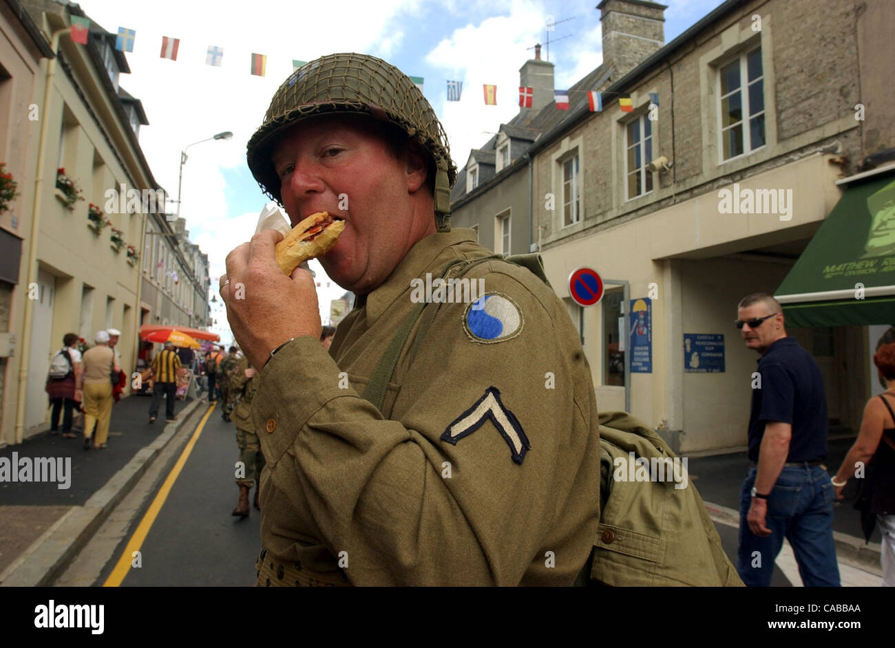 STATE - Alva Ford Jr. of Salem, W. Va, enjoys a sausage dog in the town of Ste. Mere Eglise, France, on June 5, 2004. Ford, a Navy veteran and re-enactor, wears the uniform of an Army private of the U.S. 29th Division, which landed at Normandy on June 6, 1944. American veterans and others have gathe Stock Photo