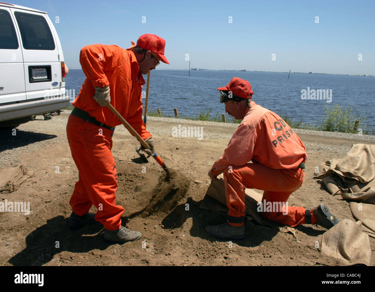 Patrick Pittman (r) and Randy Maitland, prison laborers for the California Dept. of Forestry and Fire Protection, fill sand bags to protect levees. Stuart Leavenworth Stock Photo
