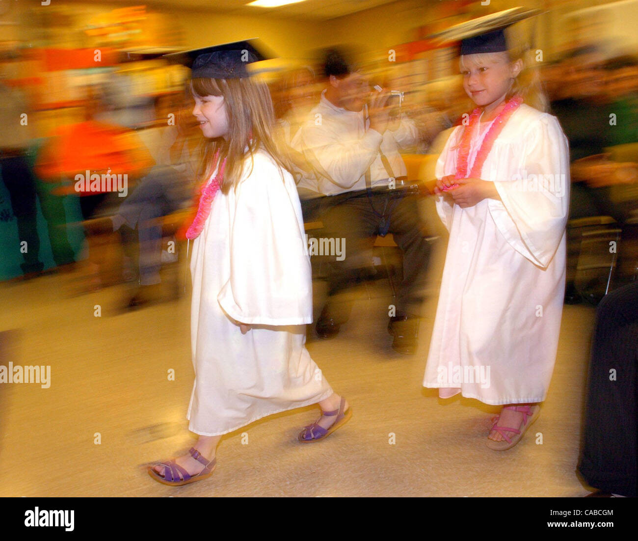 Lily Wilmot and Natalia Zuberbuhler walk into the graduation ceremony as parents watch at the preschool graduation at Alameda High on Friday June 4, 2004 in Alameda, Calif.   Eleven kids graduated from the program.  (Contra Costa Times/ Gregory Urquiaga) Stock Photo