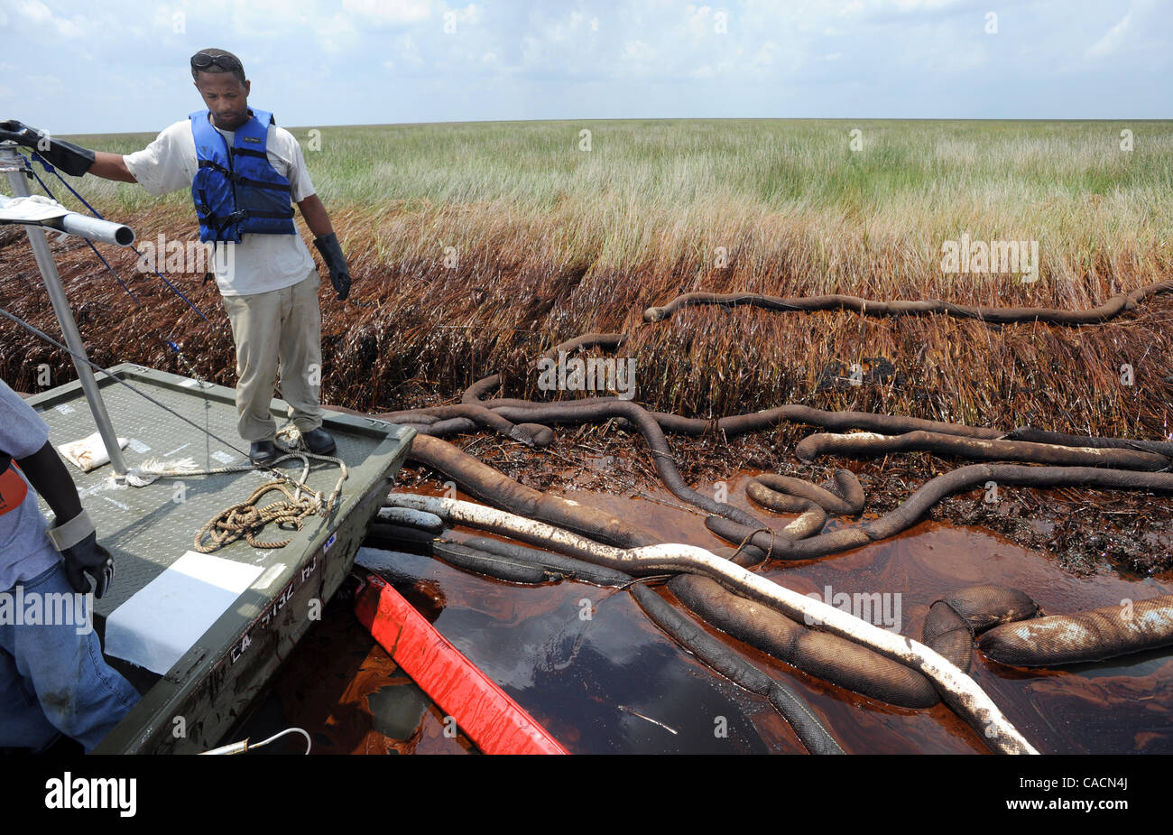 June 20, 2010 - Port Sulphur, LOUISIANA, U.S. - Plaquemines Parish employee Garland Ingraham takes a break from using a portable vacuum to suck up thick crude oil from the BP Deepwater Horizon oil spill in the Bay Jimmy marsh section of Barataria Bay near Port Sulphur, Louisiana, USA 20 June 2010. P Stock Photo
