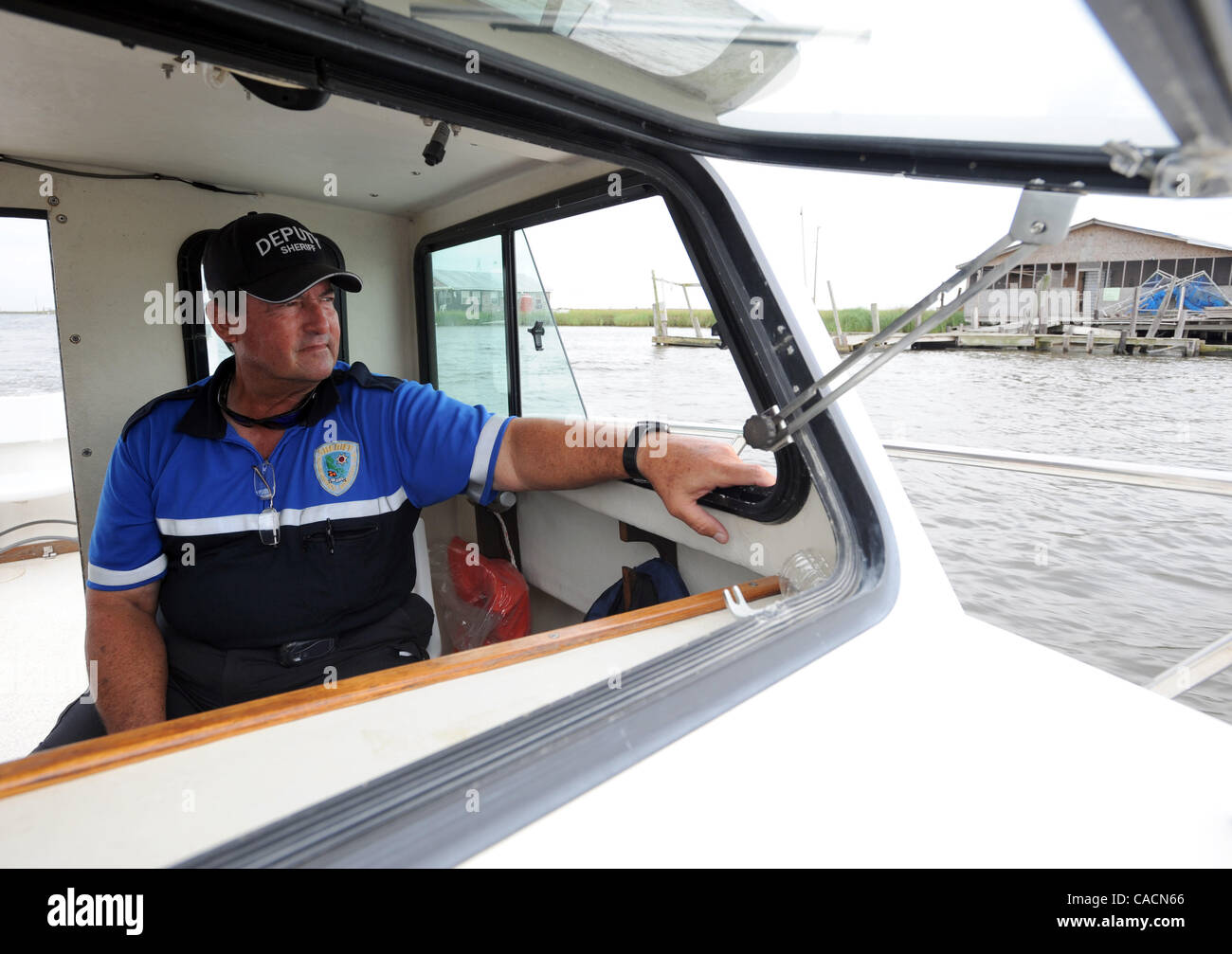 June 22, 2010 - Venice, LOUISIANA, U.S. - Plaquemines Sheriff Department marine division member Deputy Louis Fernandez keeps an eye on the Grand Bayou community of Barataria Bay near Port Sulphur, Louisiana, USA 22 June 2010. The unit has had to rescue several cleanup workers who have gotten lost or Stock Photo