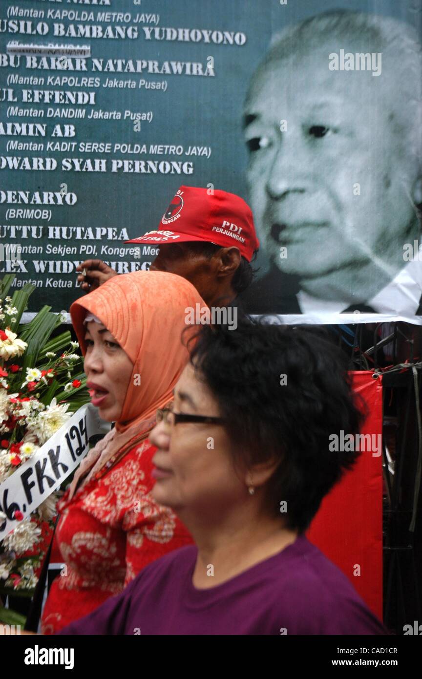 Jul 26, 2010 - Jakarta, Indonesia - Survivors of the 1996 tragedy and members of PDIP, President Megawati Sukarnoputri's political party offer flowers infornt of Suharto Potrait banner, during a ceremony in front of the ex-PDIP head office in Jakarta. PDIP members were attacked and arrested by unide Stock Photo