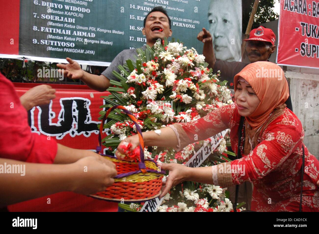 Jul 26, 2010 - Jakarta, Indonesia - Survivors of the 1996 tragedy and members of PDIP, President Megawati Sukarnoputri's political party offer flowers infornt of Suharto Potrait banner, during a ceremony in front of the ex-PDIP head office in Jakarta. PDIP members were attacked and arrested by unide Stock Photo