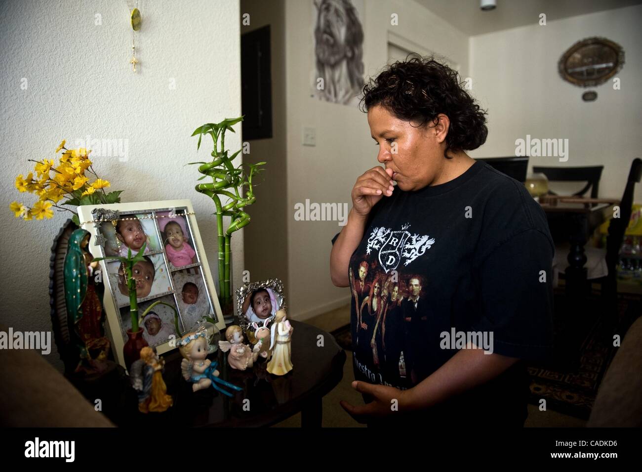 Aug. 3, 2010 - Sacramento, California, U.S. - Maria Sualeto prays over a small shrine to her late daughter Ashley in her Avenal, Calif home. Sauleto gave birth to Ashley while living in Kettleman City. The infant was born with multiple birth defects, including cleft lip and palate, holes in her hear Stock Photo
