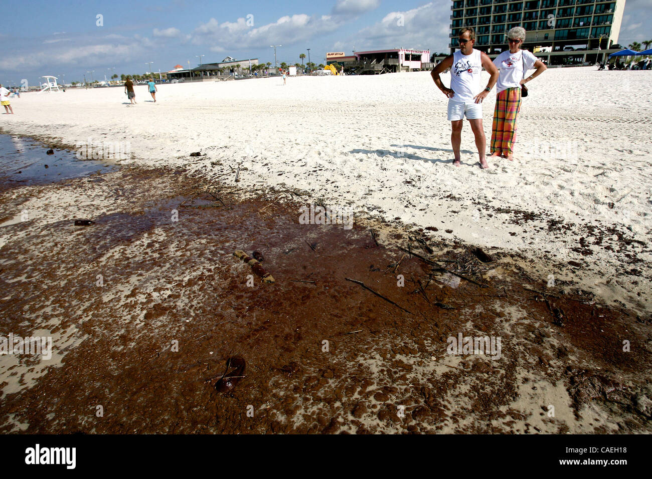 (left to right) Ricky and Lenita Braken look at a large soup of oil that washed up on the public beach in Gulf Shores, Alabama USA on June 12  2010.  A large band of oil washed up on the beach earlier in the morning. Stock Photo