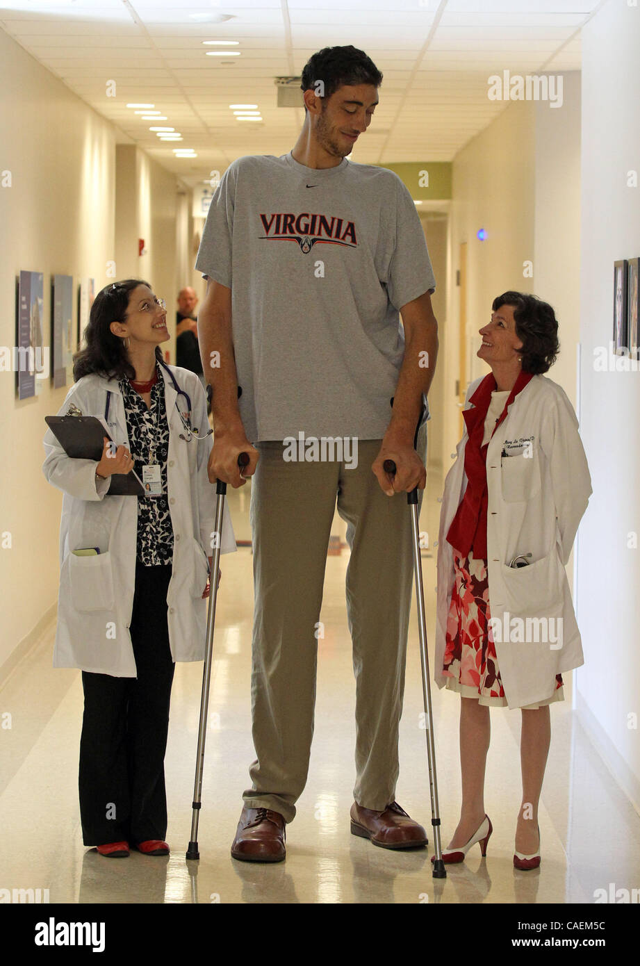Aug. 20, 2010 - Charlottesville, Virginia, U.S. - University of Virginia endocrinologists Dr. CRISTINA GHERGHE, left, and Dr. MARY LEE VANCE, right, stand with the world's tallest man SULTAN KOSEN Friday at the University of Virginia Medical Center. Turkish-born Kosen, who stands 8ft. 2inches tall,  Stock Photo