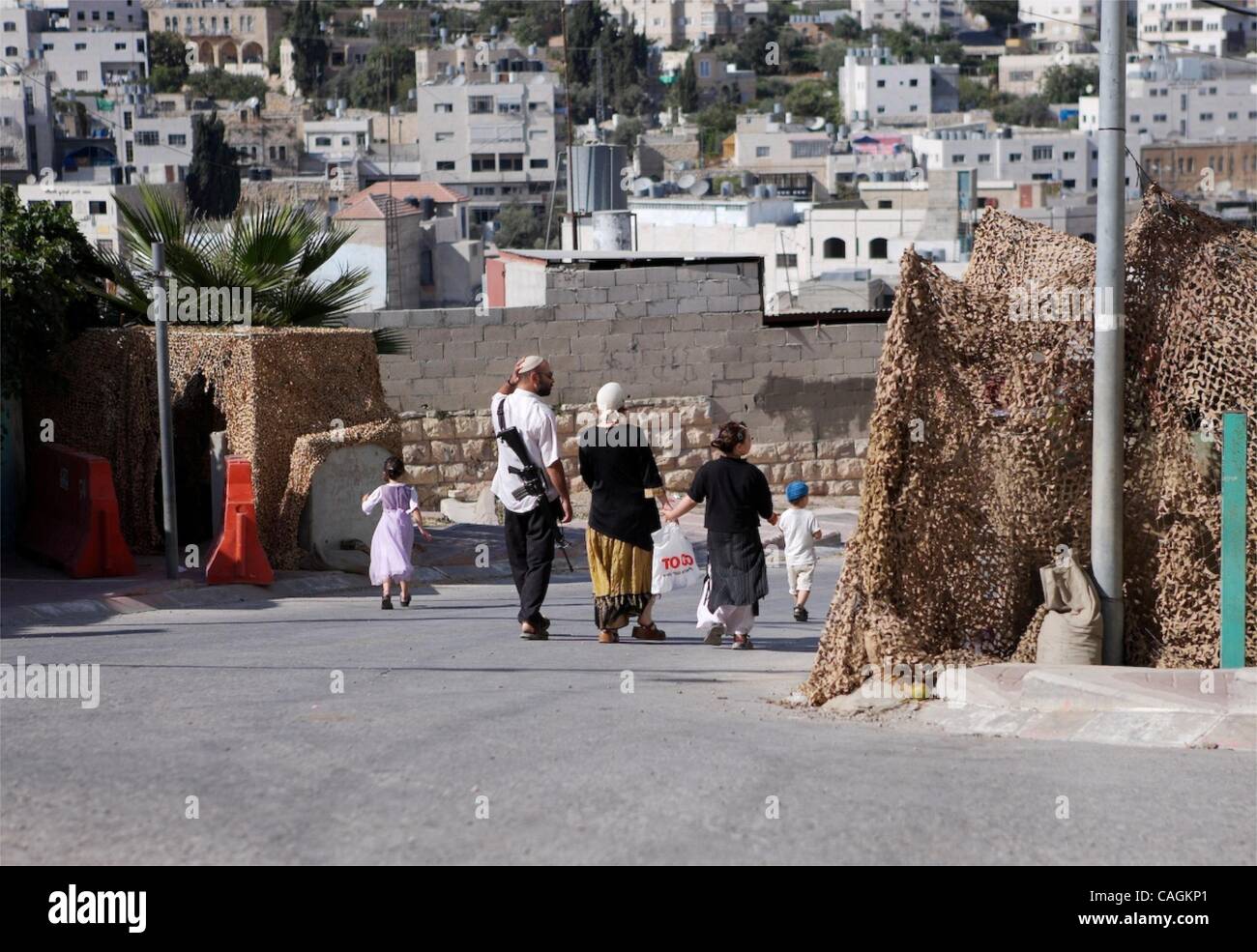 Feb 01, 2008 - Jerusalem, Israel - A Jewish settler family walking through Hebron. It is not uncommon here to Orthodox Jewish boys holding huge automatic weapons in the midst of local children playing soccer. There are 3 fortified combat stations watching this area closely as well.  (Credit Image: © Stock Photo