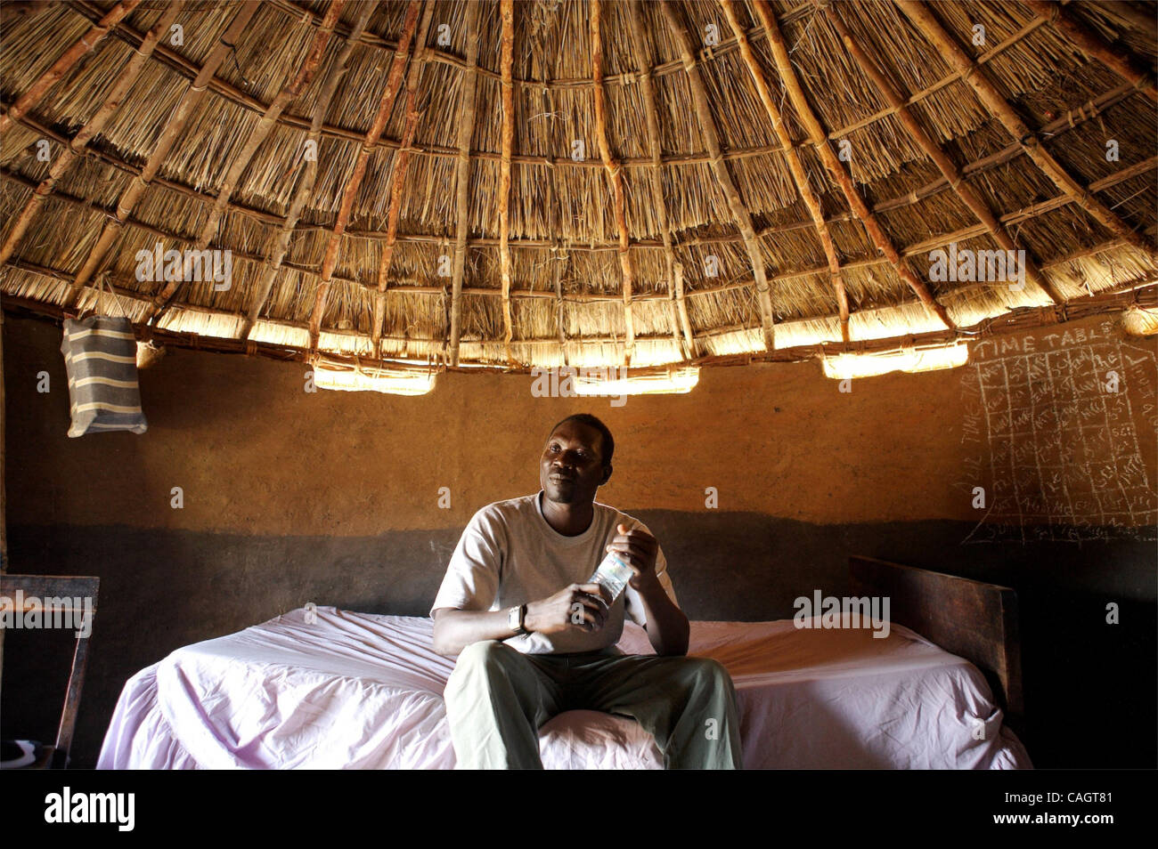 Moses Bokassa was our companion and guide through the Sudanese Refugee camps.  His family are currently refugees outside Adjumani.  This is the hut he stays in when he visits home. Stock Photo