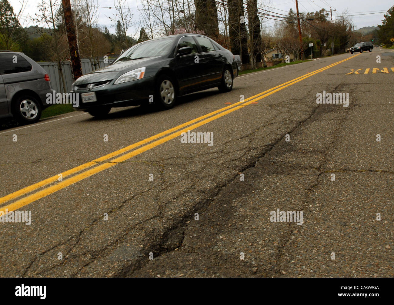 Gouges On Highway A car drives thru a section of cracks and potholes on Moraga Way in ...