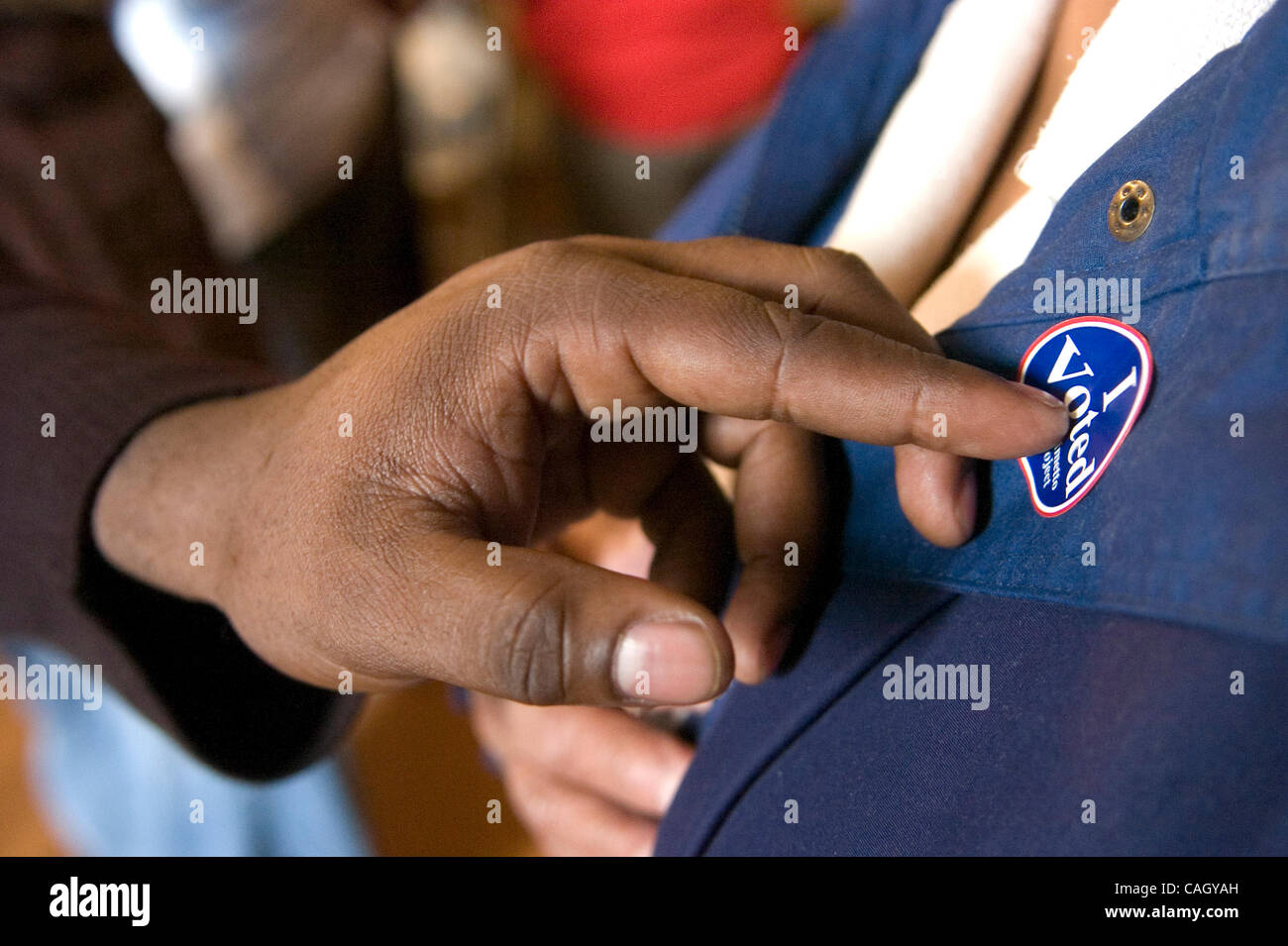 A voter receives a sticker after casting her ballot in the South
