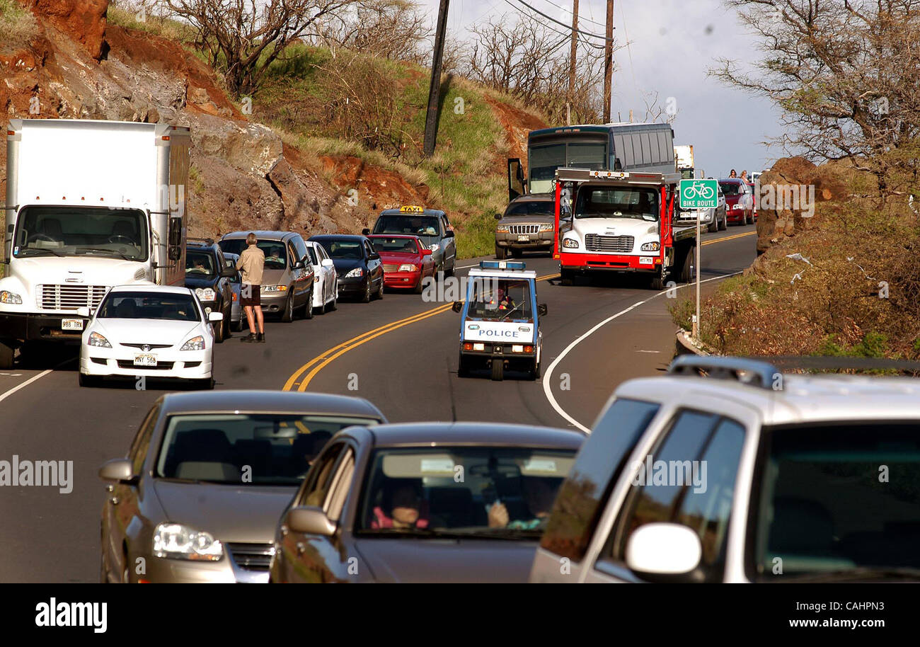 A Maui Police officer scort a tow truck into the scene of a crash on Honapiilani Hwy near