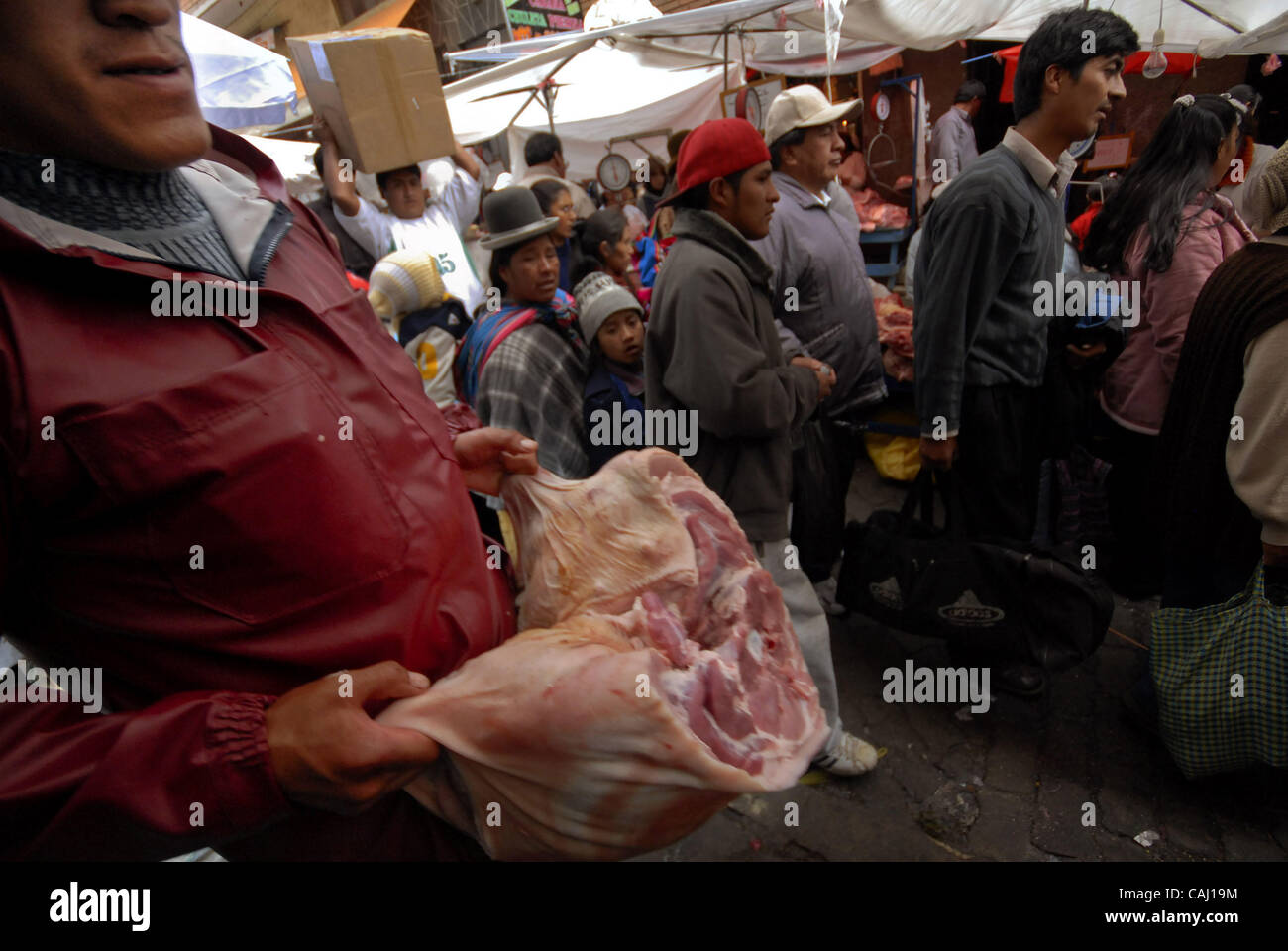 Dec 31, 2007 - La Paz, Bolivia - A man ships pork meat in La Paz Garita de Lima's street market. Every 31st December in La Paz, thousands of dead pigs are brought to the city to be sold, coming from Cochabamba, Santa Cruz and all La Paz areas. The bolivian tradition to eat pork to celebrate the new  Stock Photo