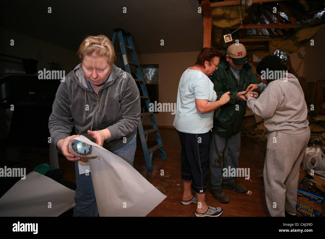 Terrie  Shapiro (cq) , left, of Sacramento packs Christmas ornaments while Anna Marie Malley, blue shirt, attends to her husband John's cut finger with help from neighbor Bonnie Meyer. They were all helping Malley's daughter after a 150-foot Digger Pine fell their Rio Linda home  this morning. The S Stock Photo