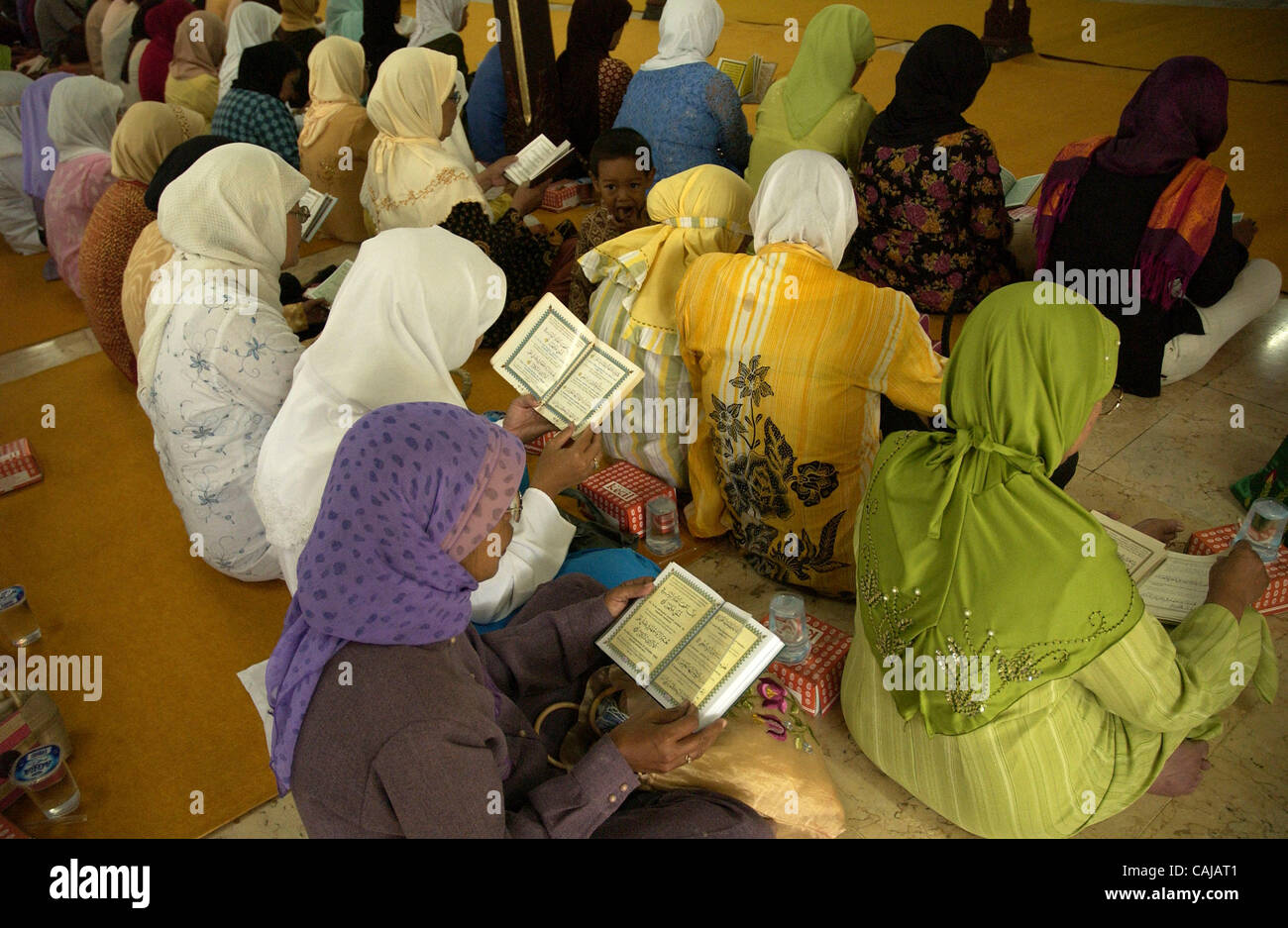 SOLO, CENTRAL JAVA, INDONESIA-JANUARY 14,2008:  Women read Koran at ndalem Kalitan, a family coumpound of suharto's late wife. Residents pray inside the coumpound to pray for better condition of the former Indonesian president after he suffered multiple organs failure.  Photo by Edy Purnomo/Jiwafoto Stock Photo