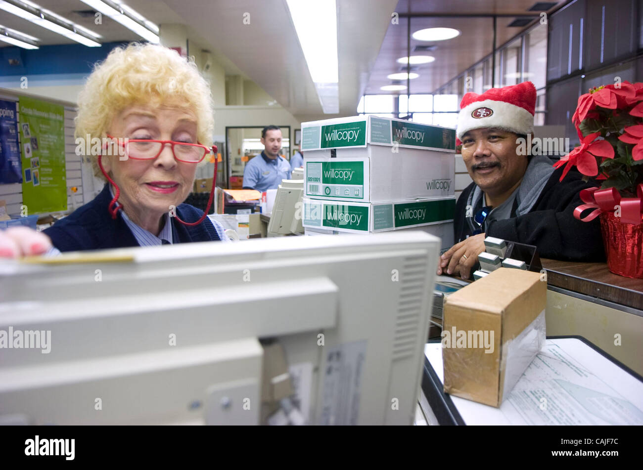 Longtime postal service employee Sally Anderson helps Gordy Gomez ship