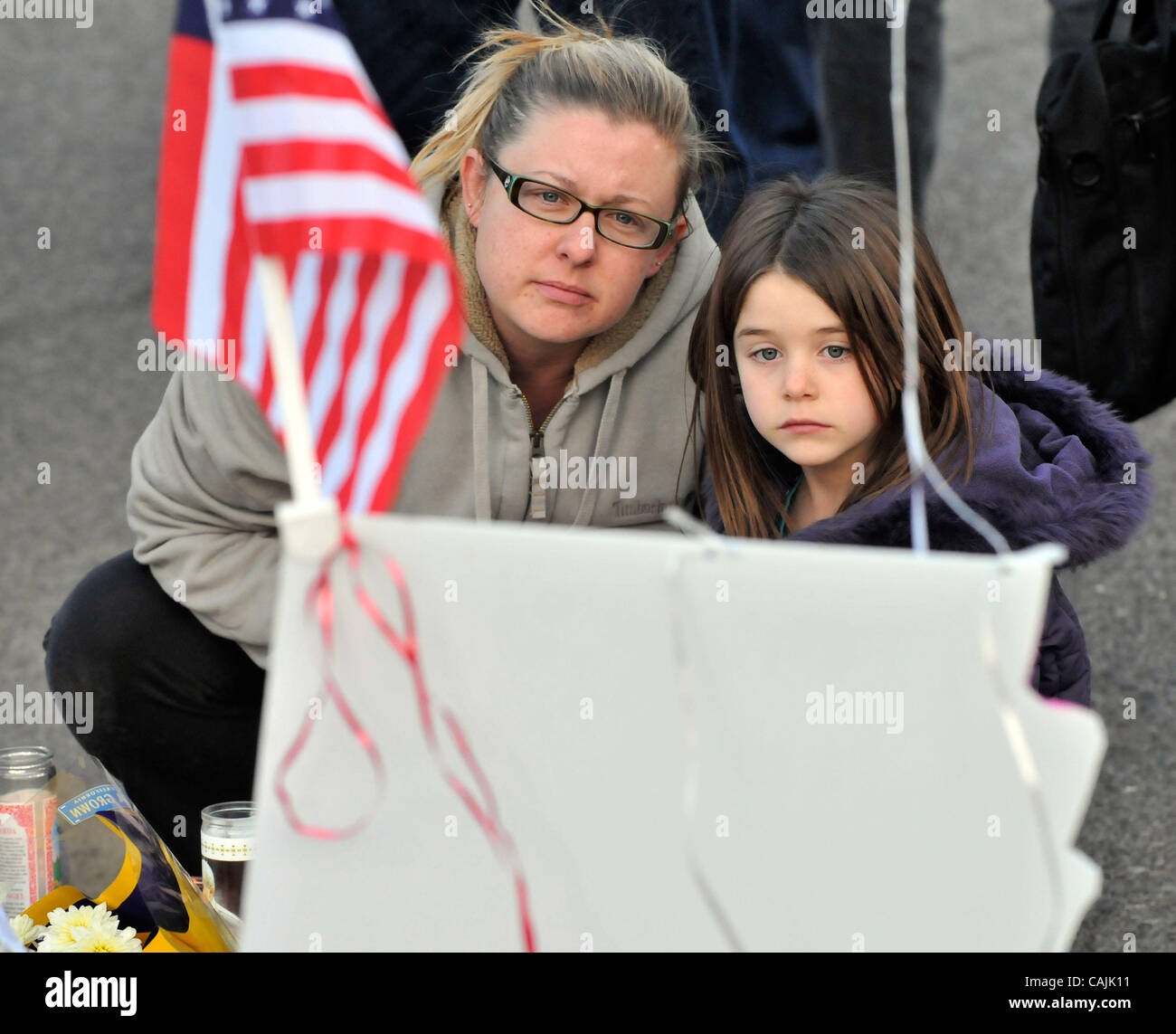 Jan. 10, 2011 - Tucson, Arizona, U.S. -  Tucson residents JESSIKAH HASELHORST (L) and her daughter SAEJE HASELHORST pay their respects at a makeshift shrine at the University Medical Center for those killed and wounded during an attack on U.S. Rep. Gabrielle Giffords (D-AZ), on January 10, 2011 in T Stock Photo