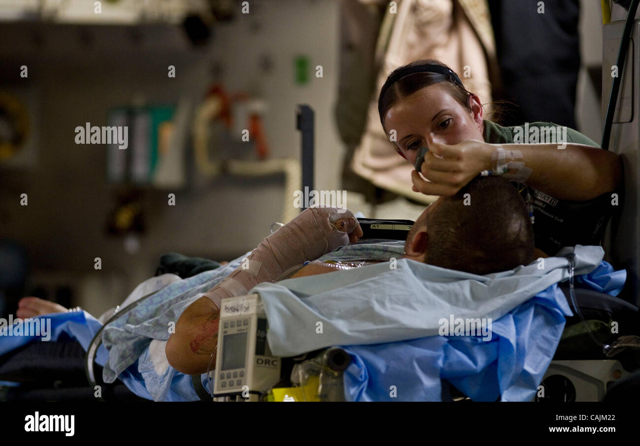 AF Senior Airman, Audry Gordon, member of the 86th AES (Aeromedical Evacuation Squadron) based in Ramstein, Air Base, Germany, tends to a seriously injured soldier wounded in Afghanistan  aboard a Mississippi Air National Guard C-17 cargo plane en route  to Andrews Air Force Base, Maryland, January, Stock Photo