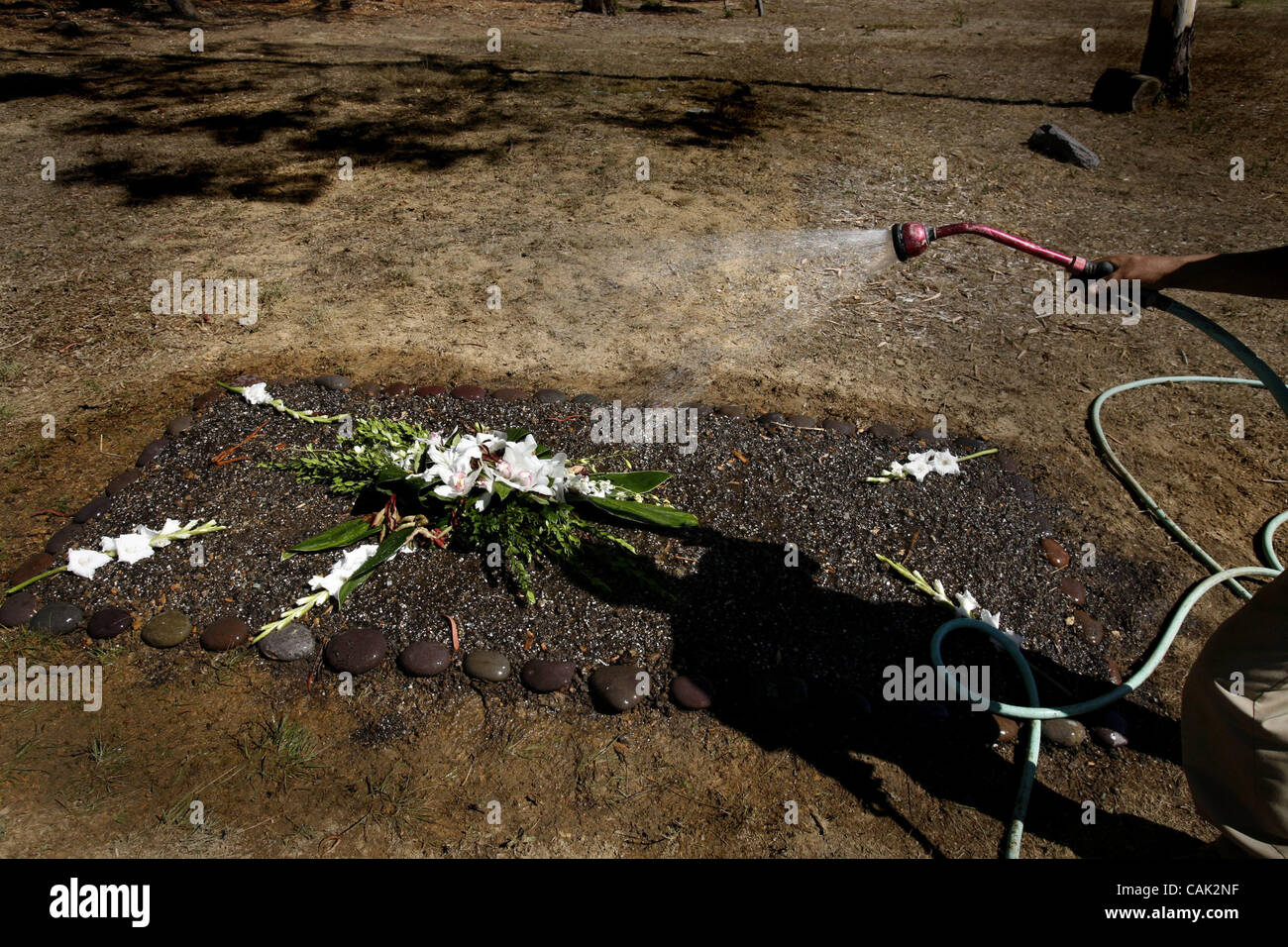 Settling the ground of a recent burial and keeping the flowers 