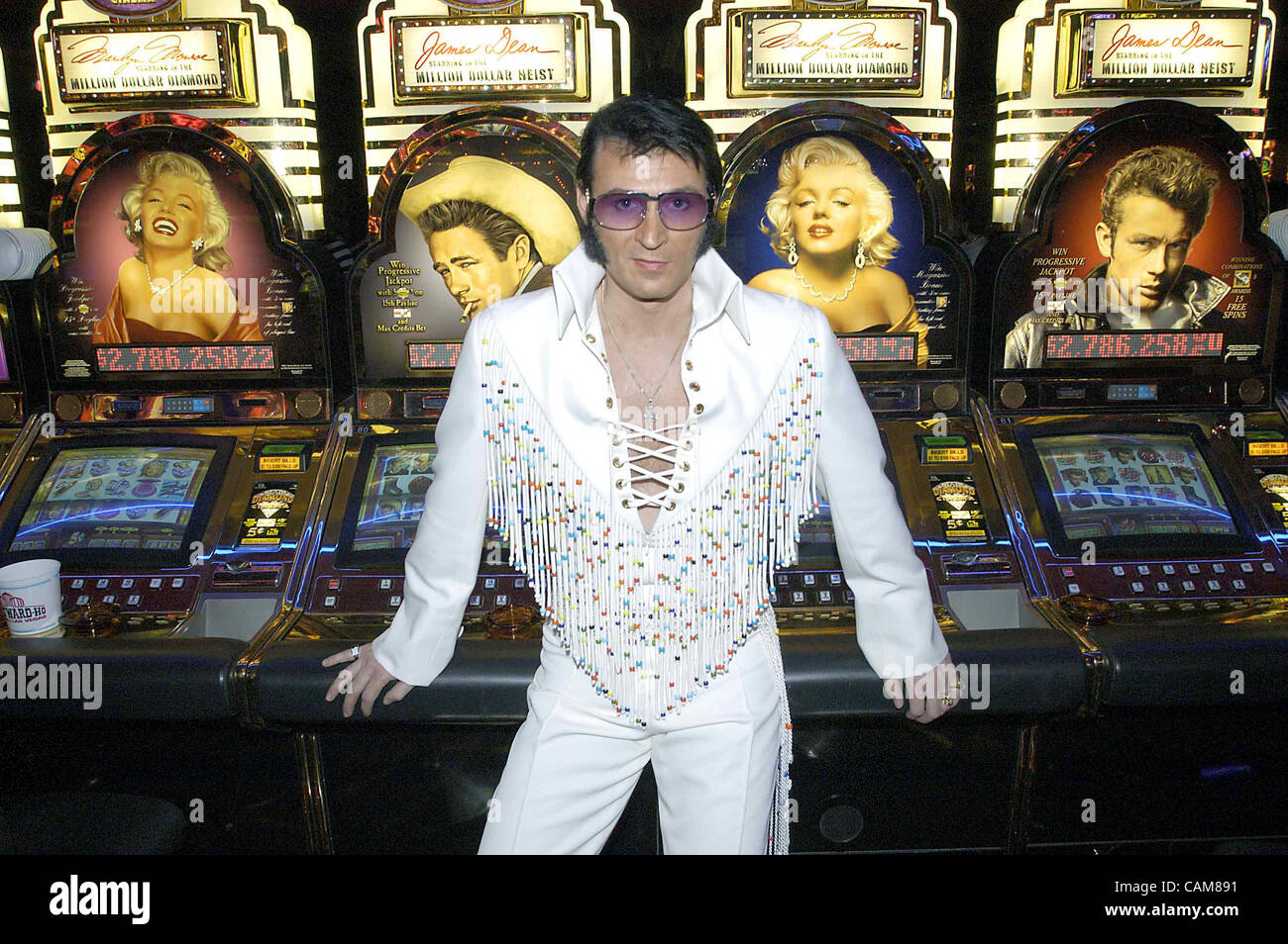 Jan. 11, 2004 - Las Vegas, USA - Switzerland's Francis Doerr poses in front of slot machines depicting two of the other American icons of the 50's before performing at the Elvis Impersonator National Finals at the Westward Ho Hotel and Casino in Las Vegas.  Competing against 40 other tribute artists Stock Photo