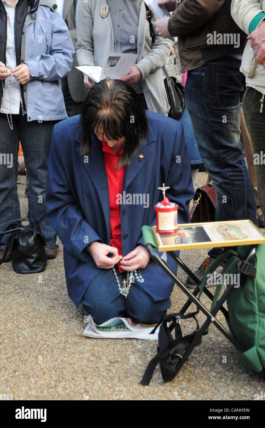 London, UK. 30/03/12. A woman kneels in prayer, as Christian Pro-Life and Anti-Abortion campaigners held protests outside the British Pregnancy Advisory Service in Bedford Square. Stock Photo