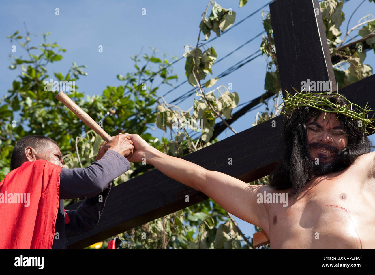 Cebu City, Philippines, Good-Friday, 6.April 2012: Gilbert Bargayo, being nailed to the cross for the 17th Good Friday.  The removal of the nails is extremely painful. Stock Photo