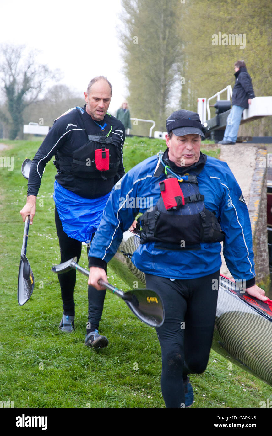 Devizes, UK. 07 April 2012. Sir Steve Redgrave (rear) and Roger Hatfield running the first portage at Crofton locks on the Kennet and Avon Canal. They started the 125 mile race in Devizes at 09.45 on Easter Saturday and expect to take approx. 22 hours to finish. Stock Photo