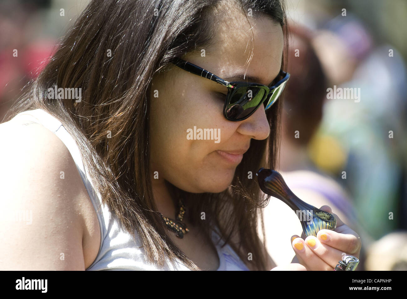 April 7, 2012 - Ann Arbor, Michigan, U.S - A lady takes a bowl hit during the 41st annual Hash Bash on the University of Michigan campus in Ann Arbor, MI on April 7, 2012. (Credit Image: © Mark Bialek/ZUMAPRESS.com) Stock Photo