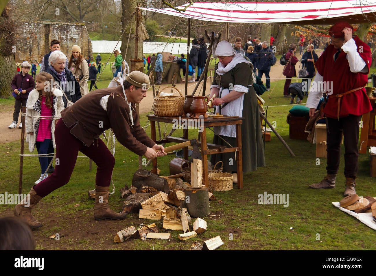 a-man-chops-wood-and-a-woman-prepares-food-medieval-style-at-the
