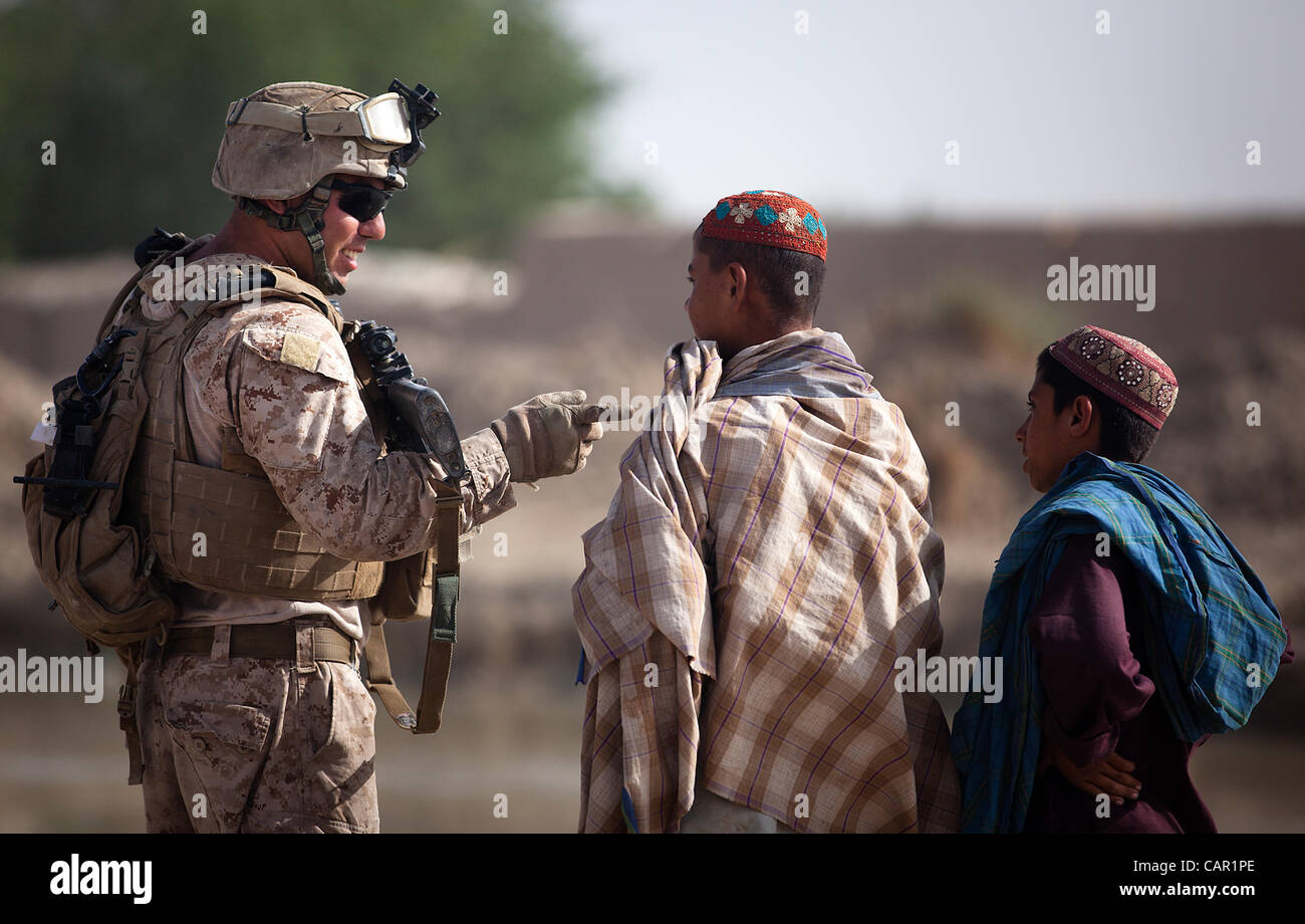 U.S. Marine Cpl. Tarek Houssamy (left), a squad leader with 4th Platoon, Kilo Company, 3rd Battalion, 3rd Marine Regiment, and 27-year-old native of Cocoa Beach, Fla., interacts with Afghan children during a security patrol here, April 10, 2012. Stock Photo