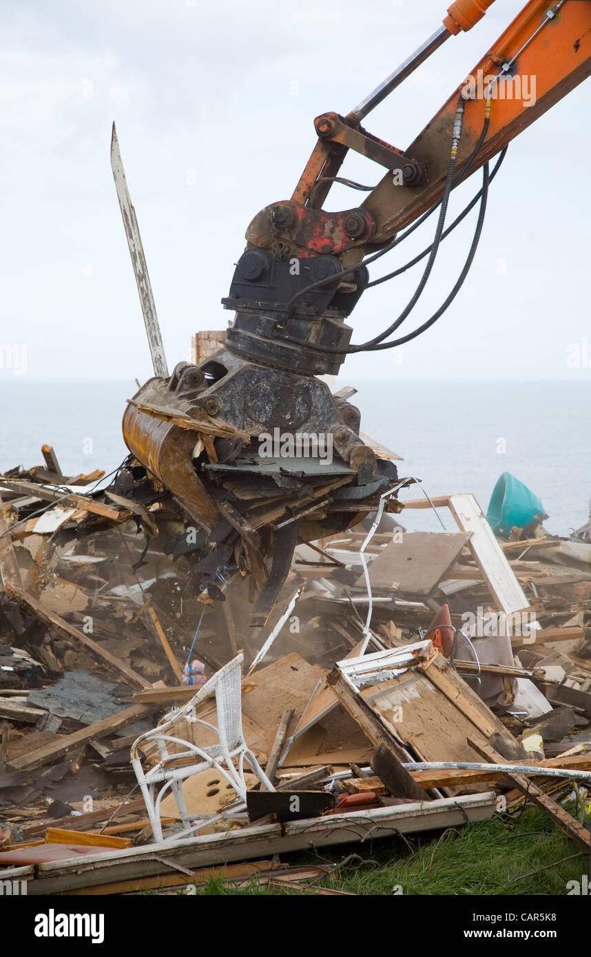 Excavator with demolition grab or selector grab, working on a demolition site in the UK. It is sorting through demolition rubble & waste. Stock Photo