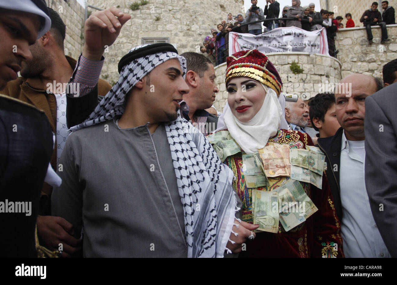 April 12, 2012 - Nablus, West Bank, Palestinian Territory - The Palestinian bride and groom Mhaha Salam (R) and Thayer Qasem (L), walk down the street on their wedding day on April 12, 2012  Stock Photo