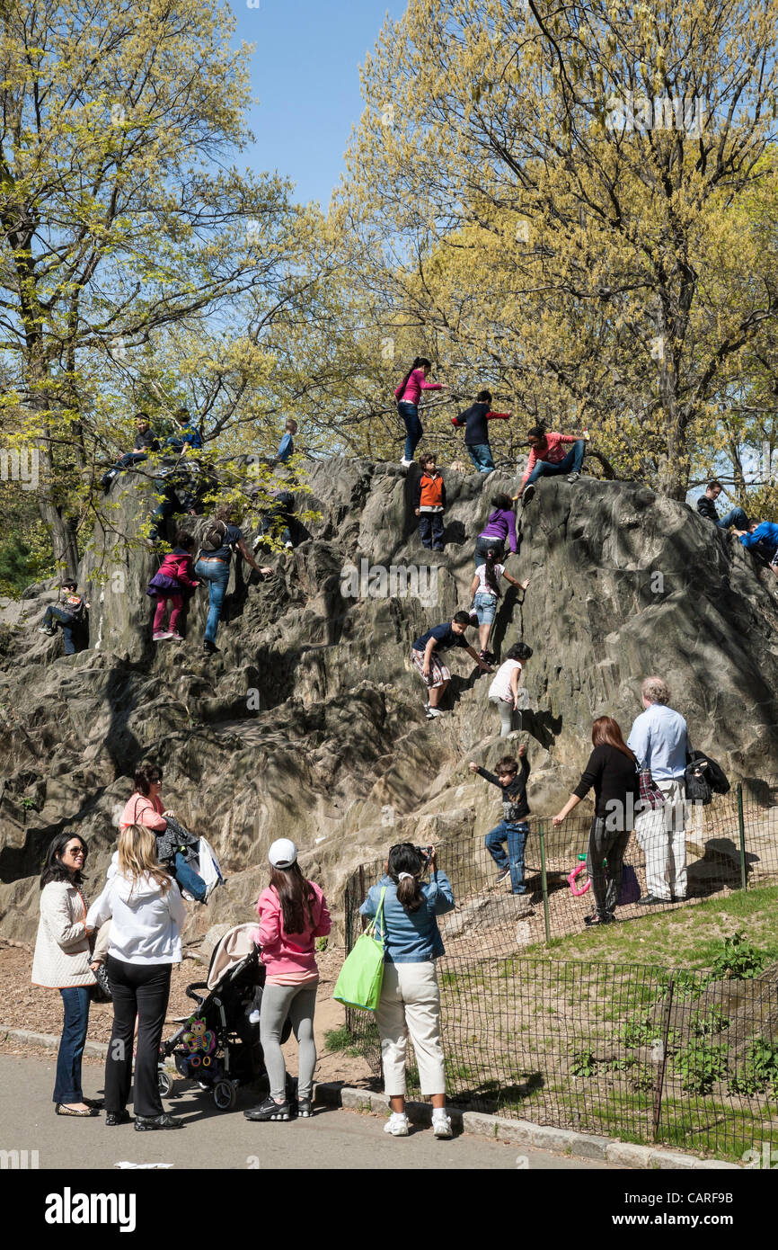 New York, NY – 13 April 2012 – Unseasonably warm weather made Central Park a perfect place to enjoy and relax.  Rocky outcrops prove irresistible to energetic children. Stock Photo
