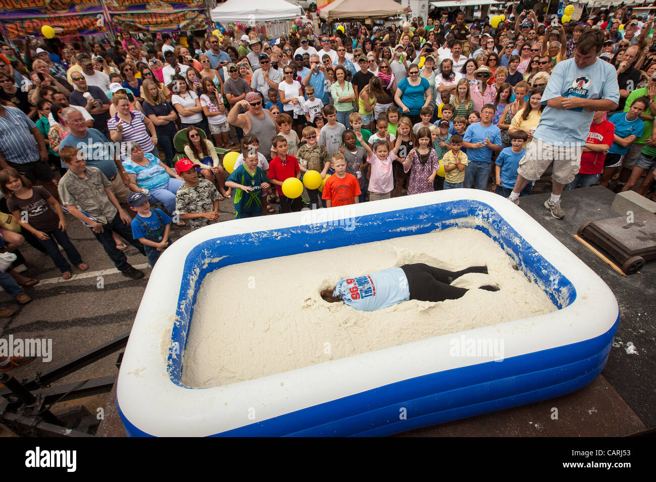 A competitor lays face down in a pool of instant grits during the grits