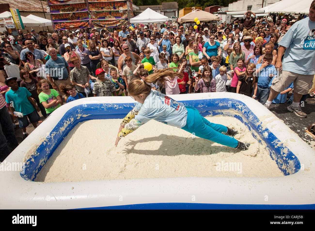A competitor dives into a pool of instant grits during the grits roll