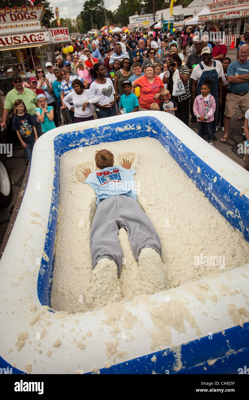 A competitor dives a pool of instant grits during the grits roll